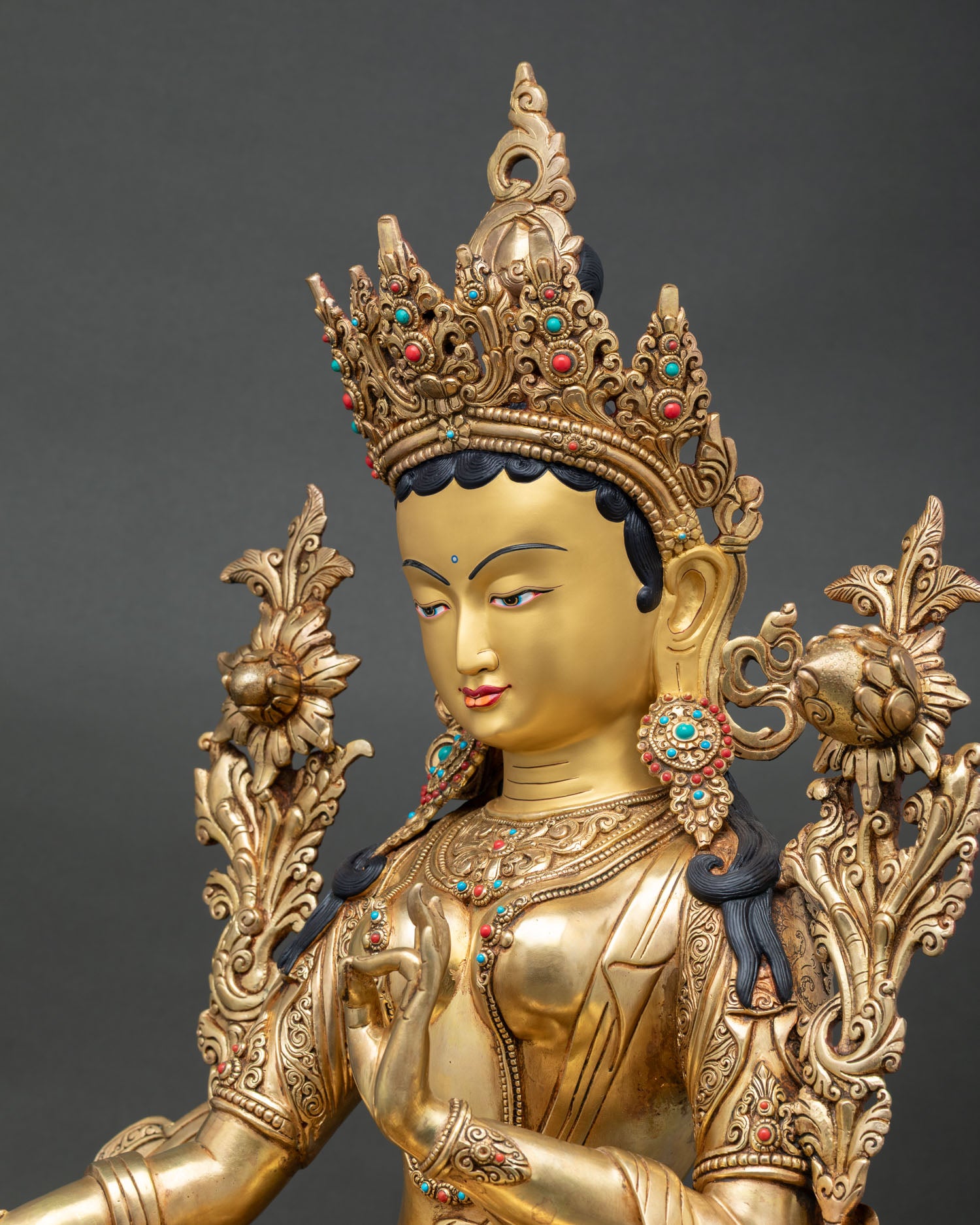 Close detail of Green Tara with Five Jeweled Crown, handcrafted earrings, and radiant fire gold gilding.