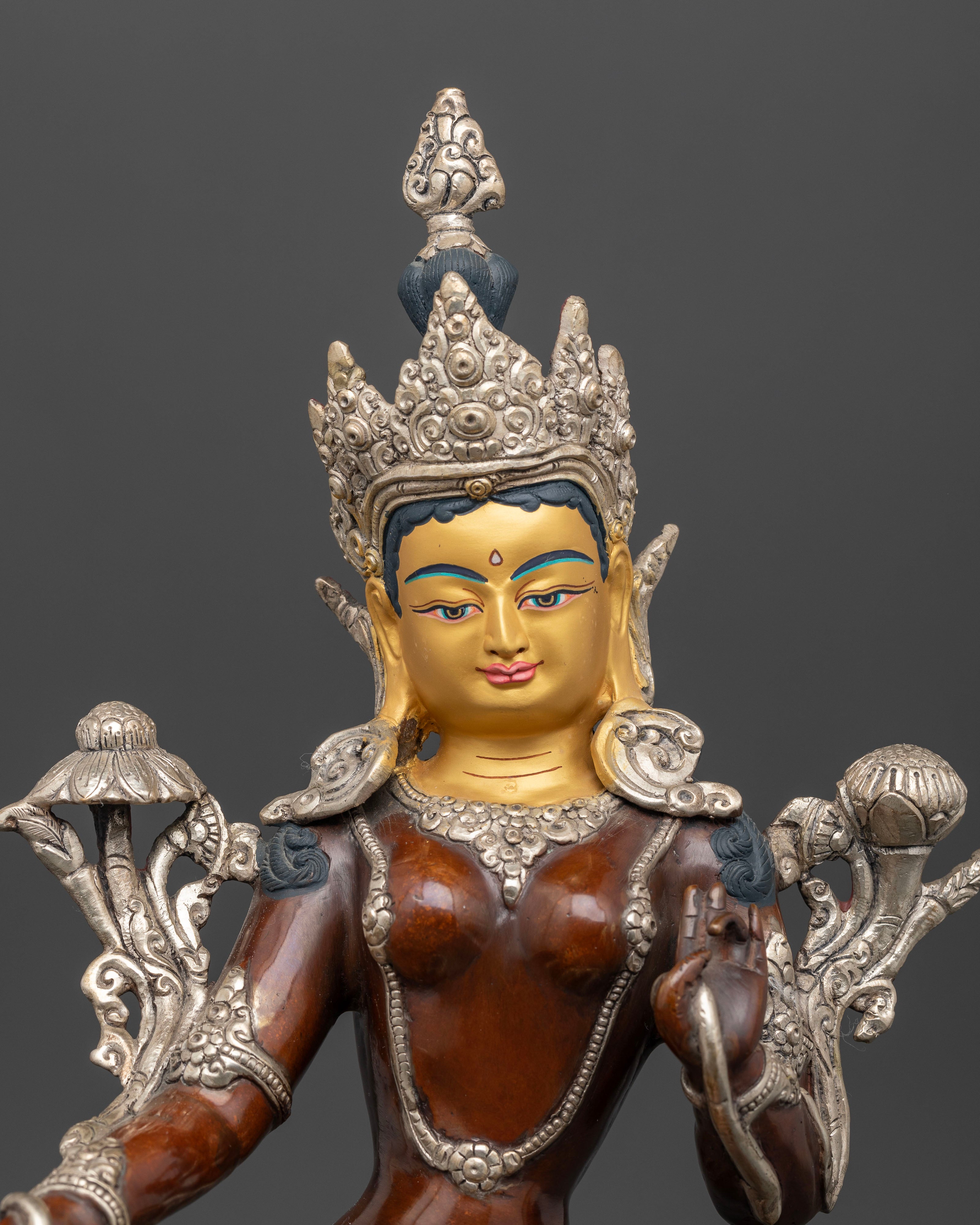 close up Green Tara statue gold painted face, utpala flowers Himalayan Bodhisattva