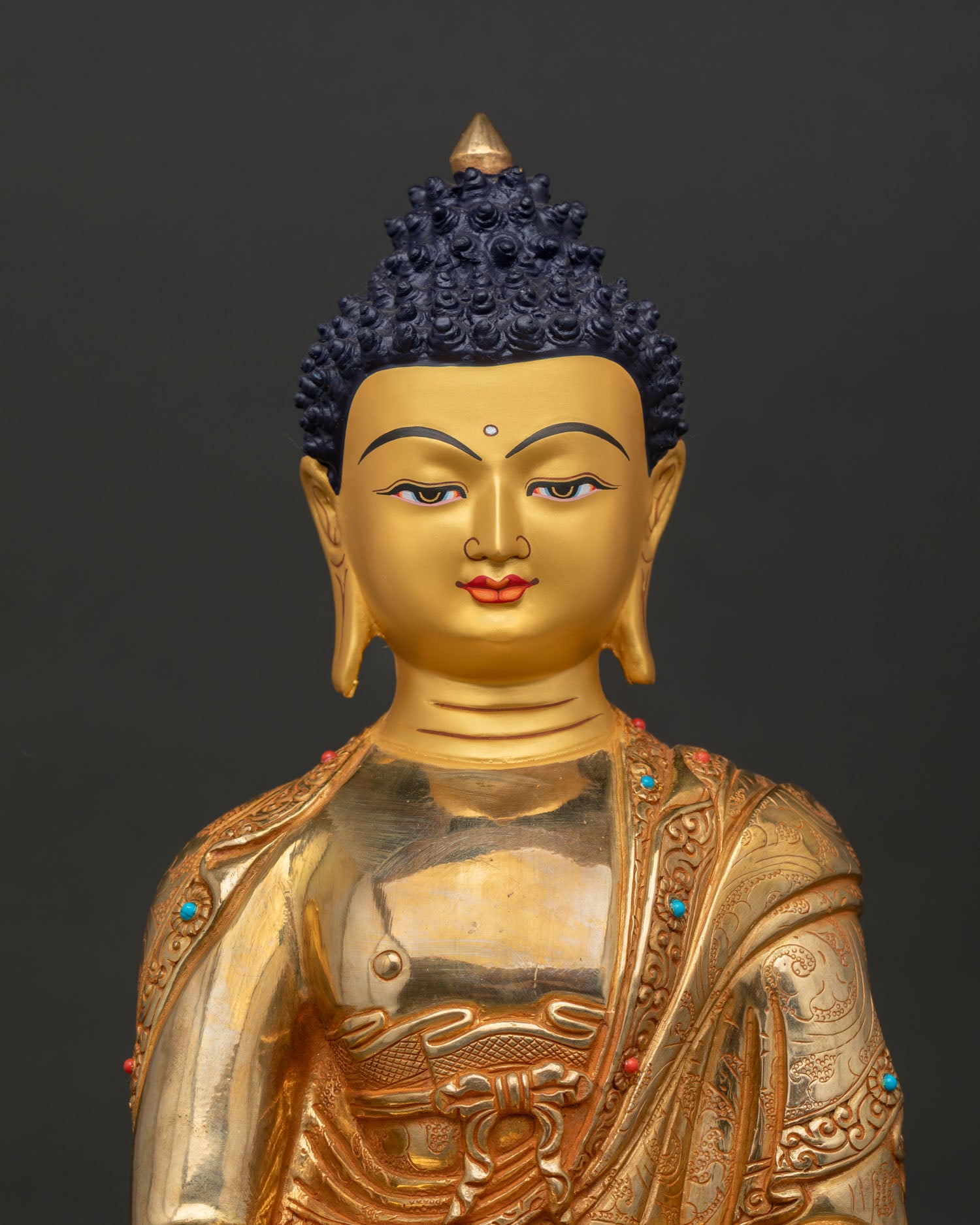 Close up Amitabha Buddha statue gold painted face serene expression, Buddhist art from Nepal