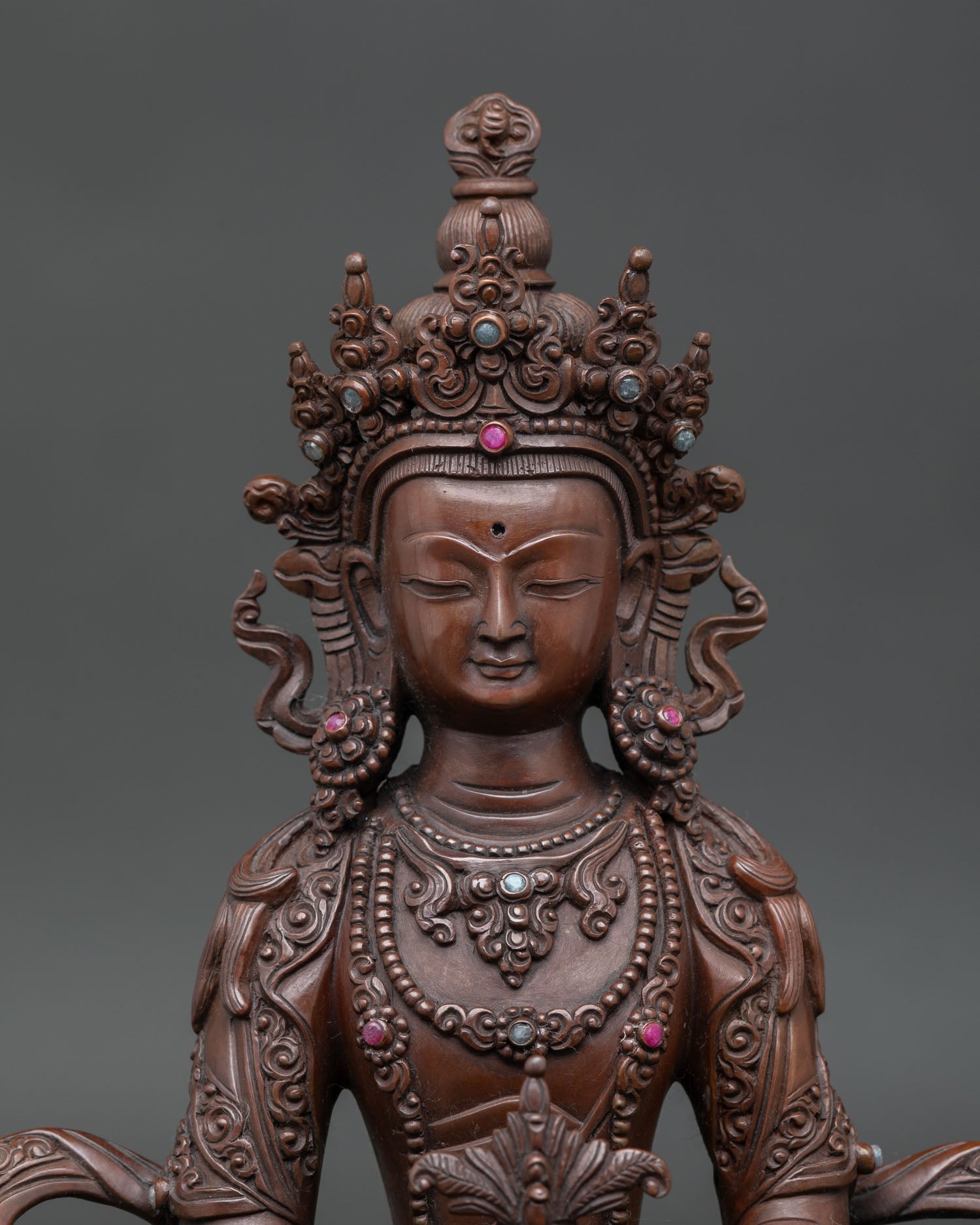 Close up Amitayus face serene expression Buddha of longevity Himalayan copper sculpture with oxidized finish