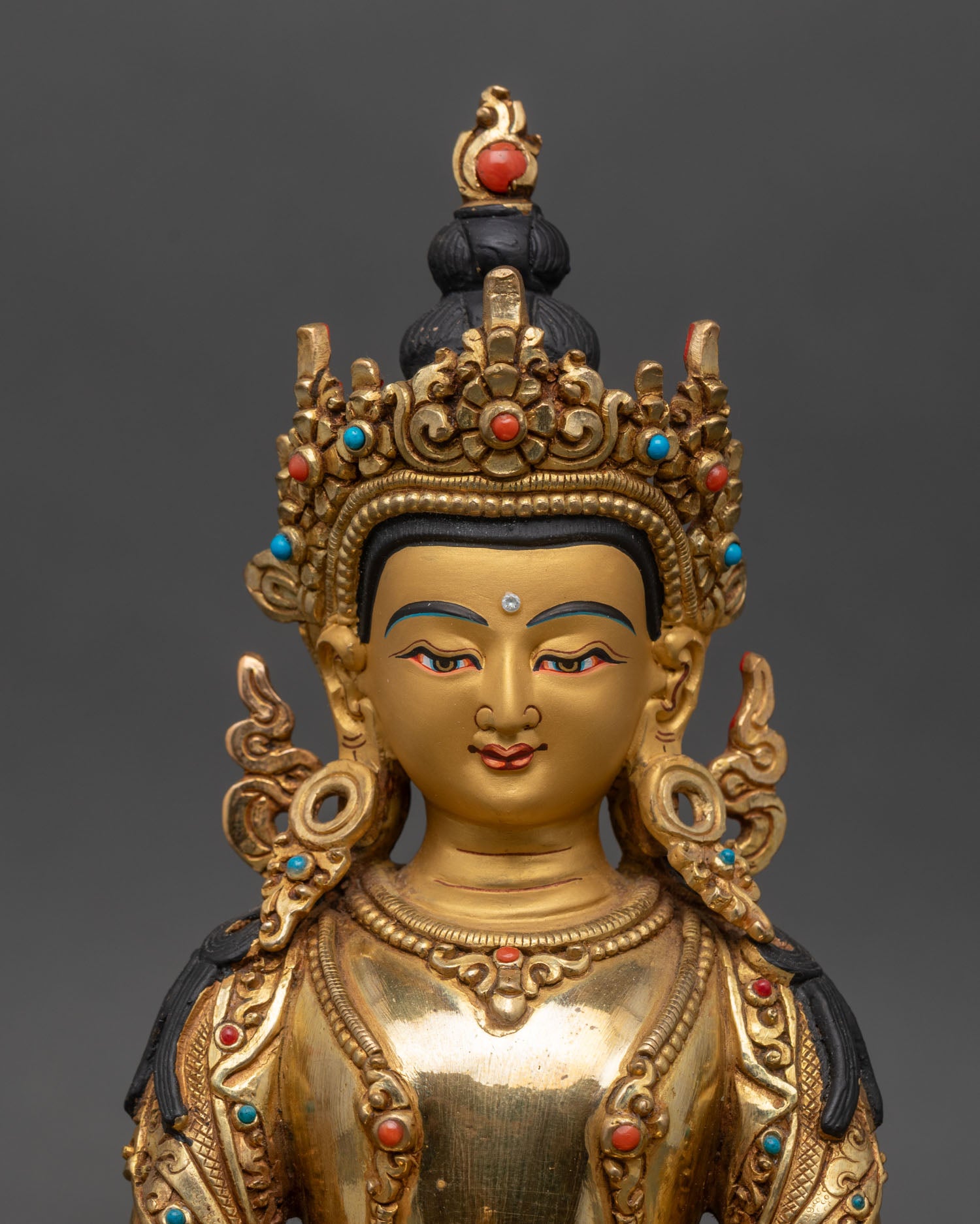Close up Amitayus face serene expression gold painted jeweled details