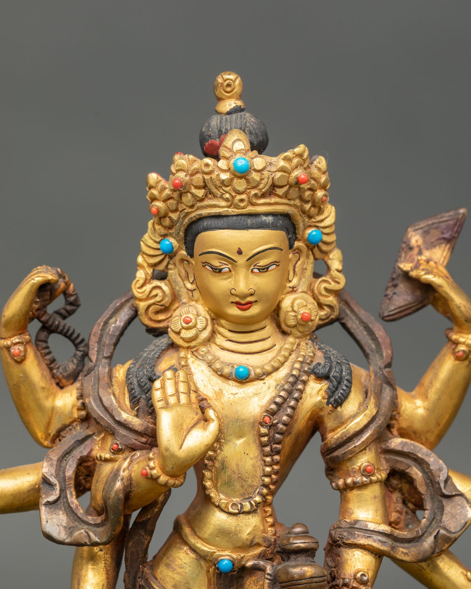 Close up Amoghapasa Lokeshvara face detail gold painted expression Himalayan Buddhist art Newari craftsmanship
