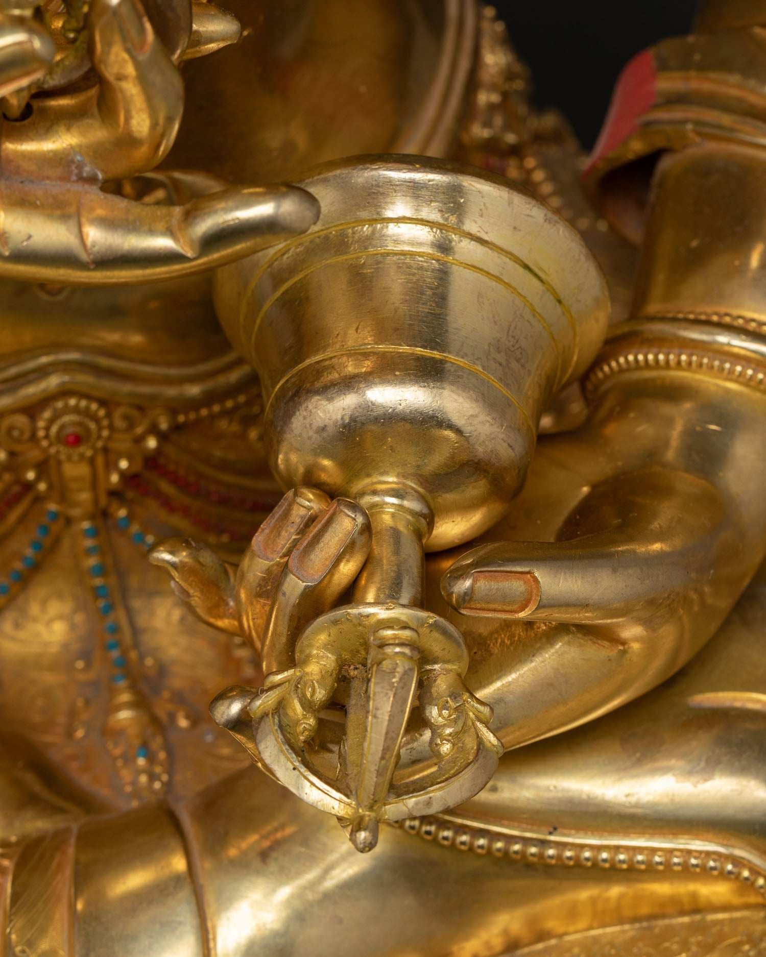 Close-up bell ghanta held in Vajrasattva right hand copper gold 24K gilded detail Nepal