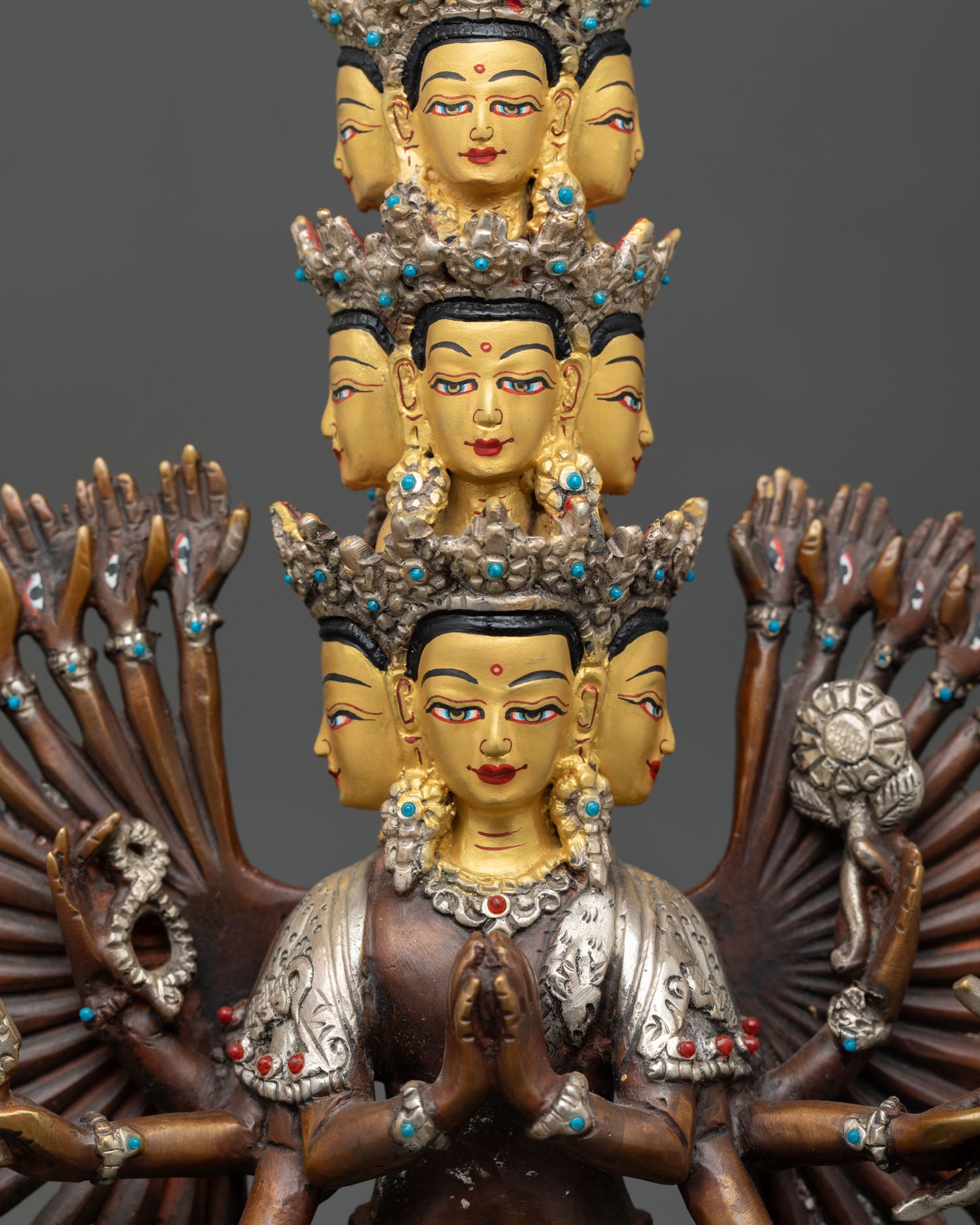 Close up Chenrezig statue, 11 serene gold painted faces with turquoise coral semi precious stone details