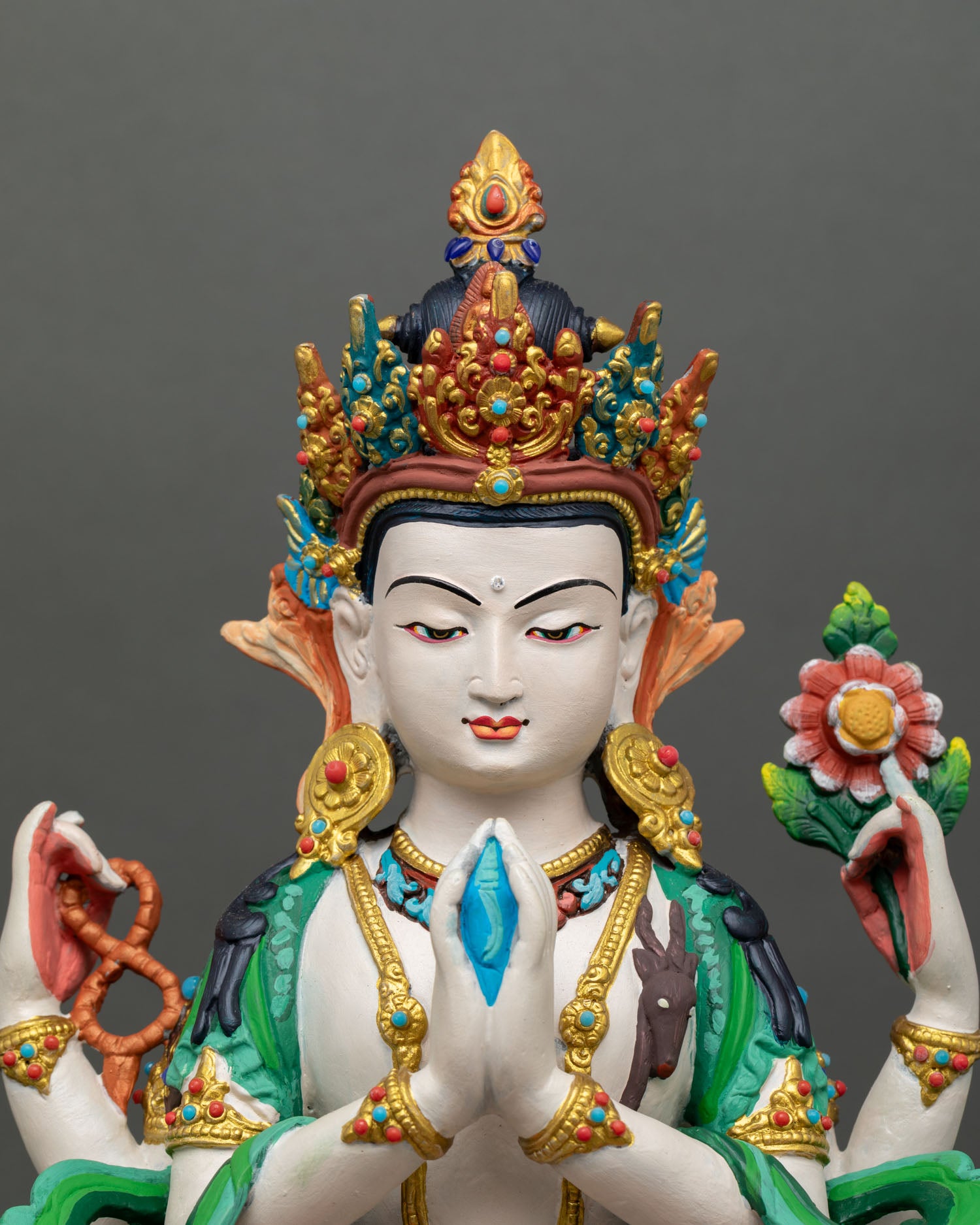 Close-up Chenrezig face with serene expression gold-accent ornaments acrylic painted details sacred Avalokiteshvara meditation statue Nepalese art