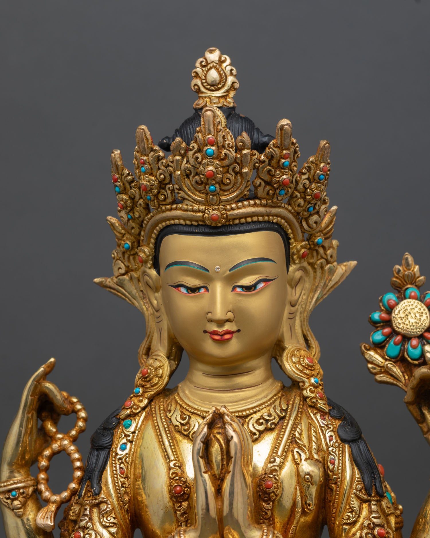 Close up Chenrezig statue face serene wish fulfilling jewel turquoise coral stones