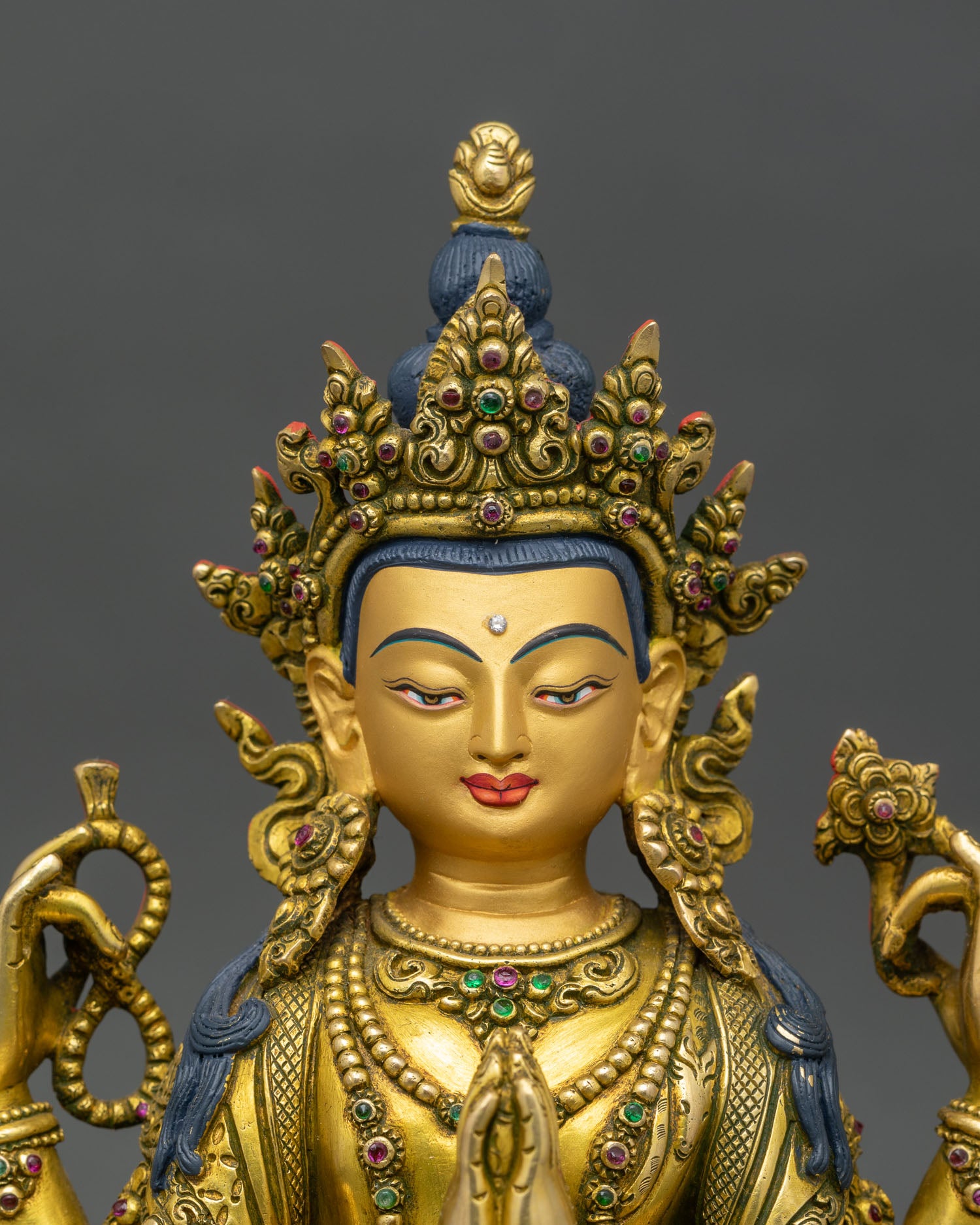 close-up chenrezig statue showing intricate copper, gold, and gemstone details