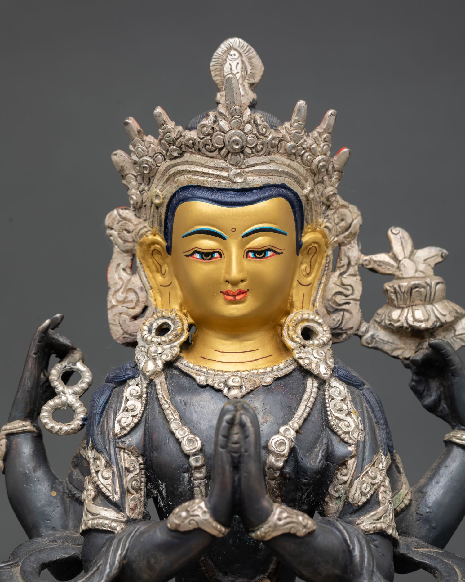 Close up Chenrezig statue showing serene compassionate expression with intricate Nepalese craftsmanship