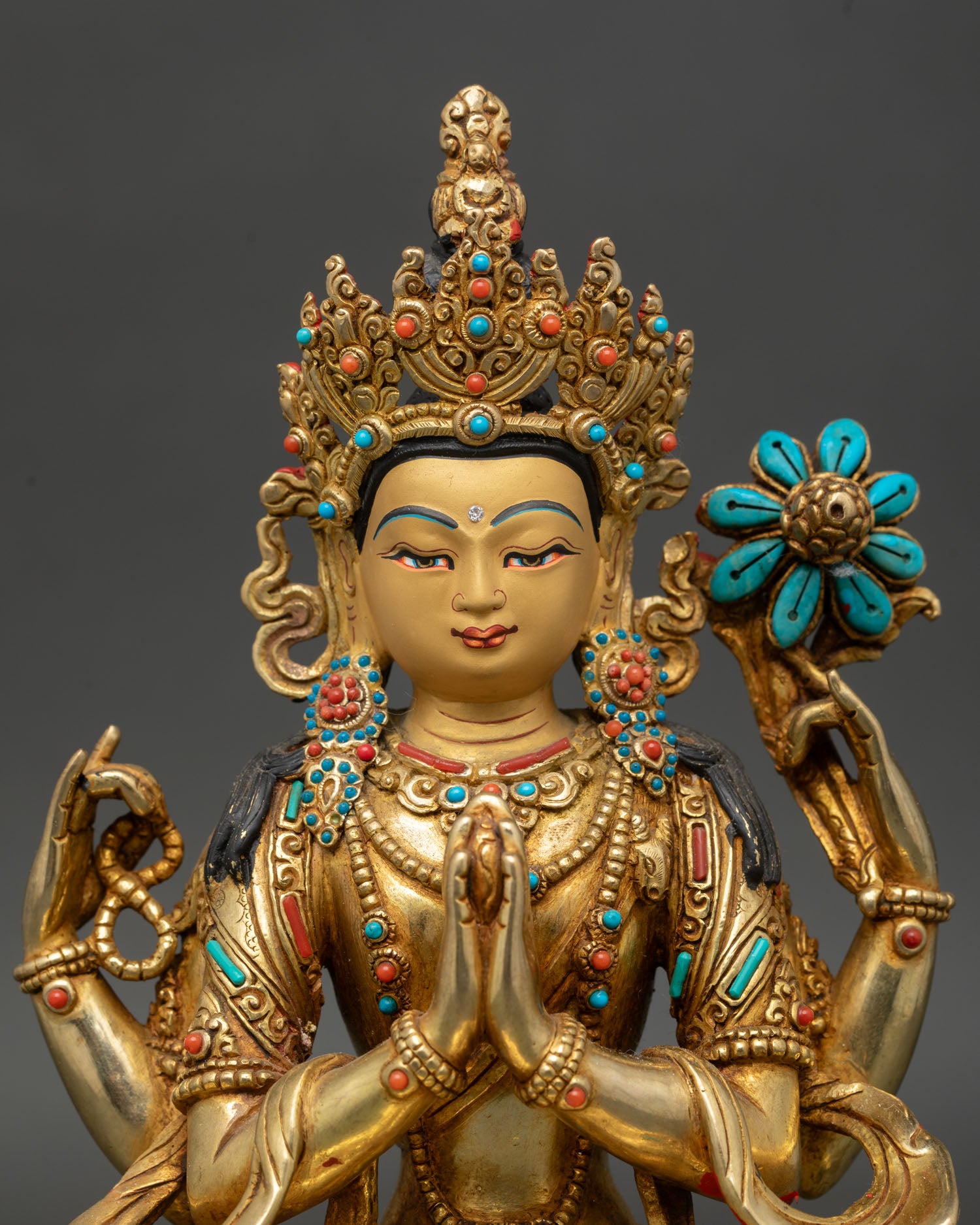 Close up Chenrezig statue turquoise coral stones gold face Avalokiteshvara detail