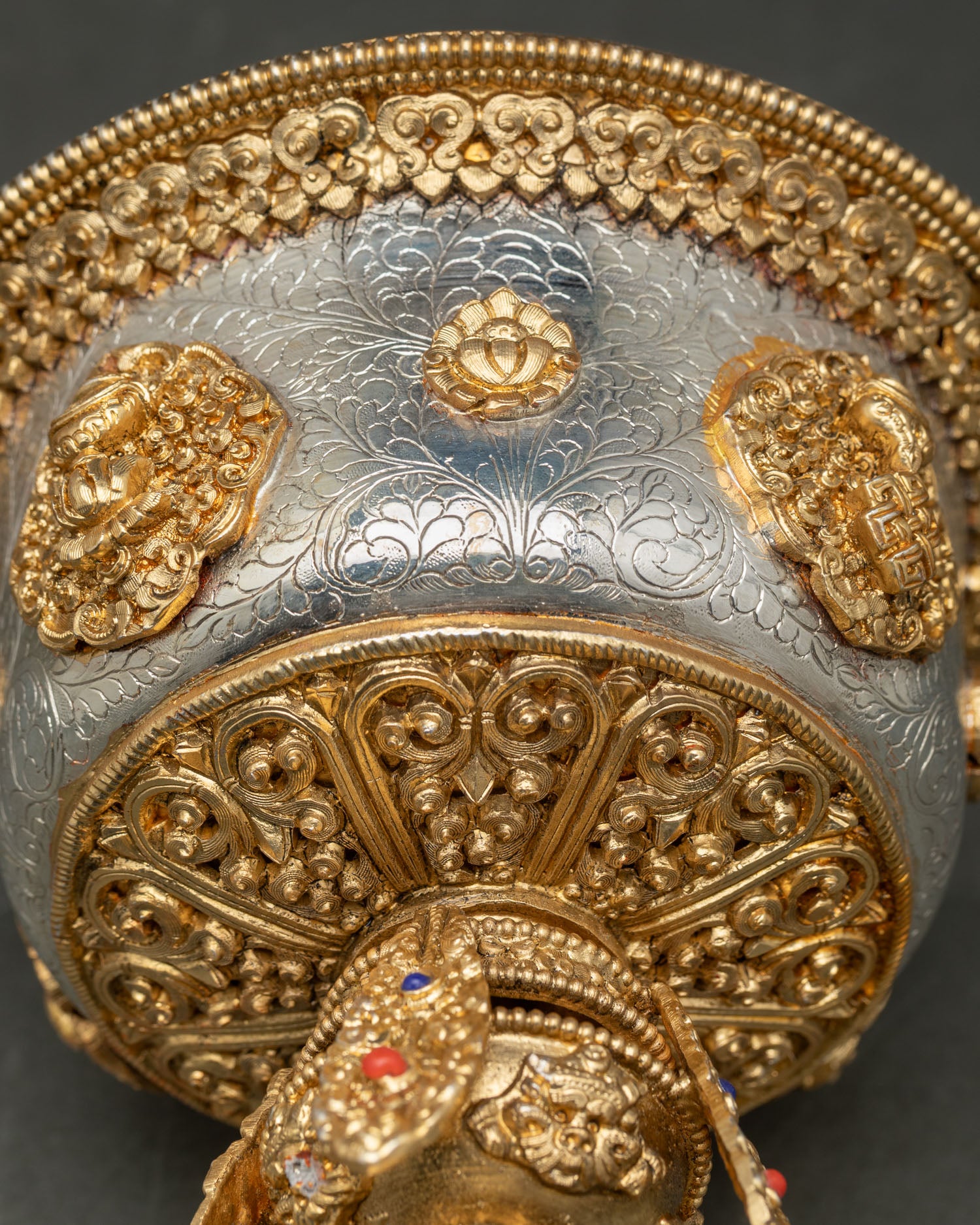 Close up detail butter lamp showing intricate floral motifs delicate filigree carving and sacred Buddhist symbols with gold and silver plated