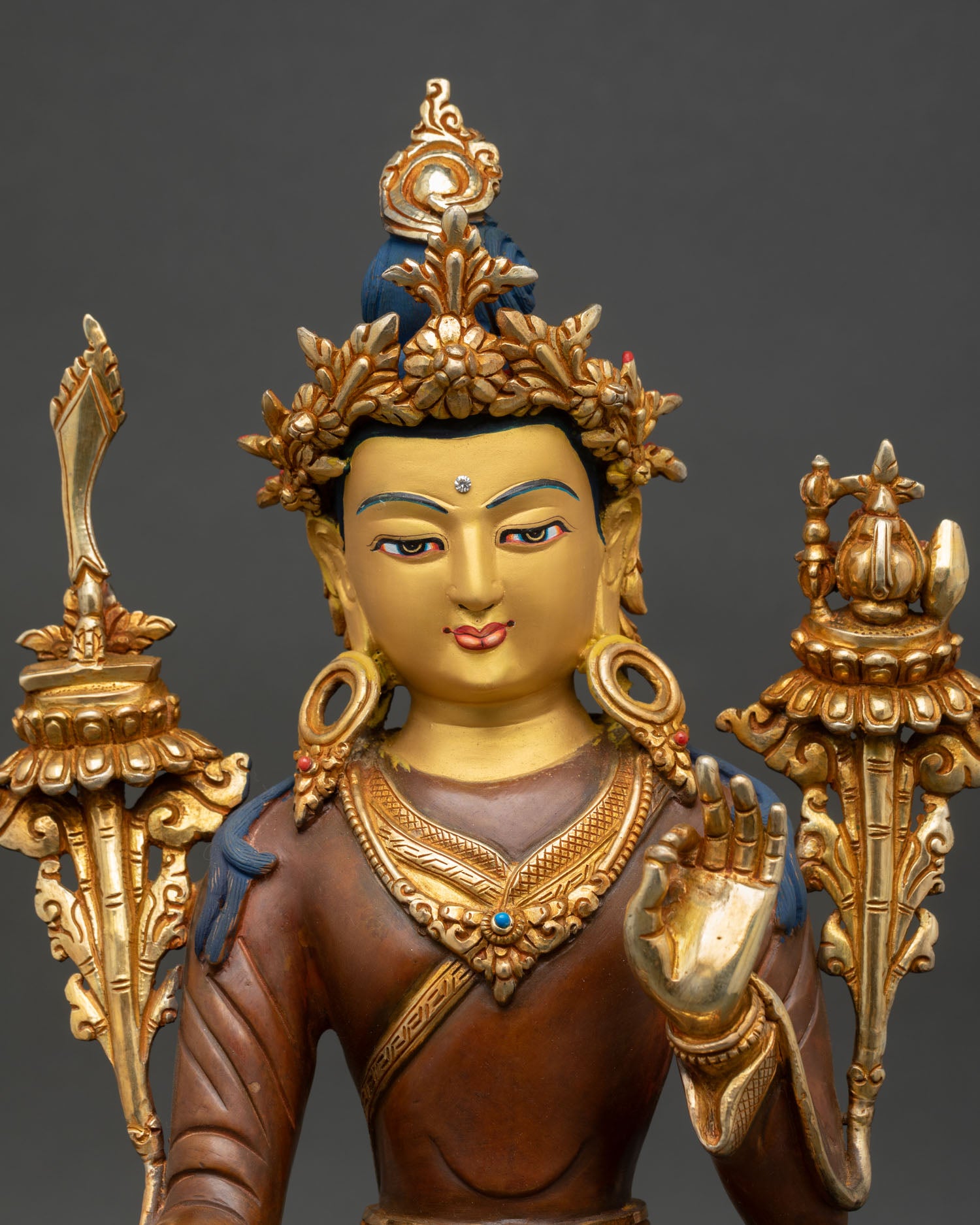 Close up detail of Yuthok Yonten Gonpo face and monastic robe showing gold painted expression intricate Buddhist motifs and traditional Himalayan Newari craftsmanship