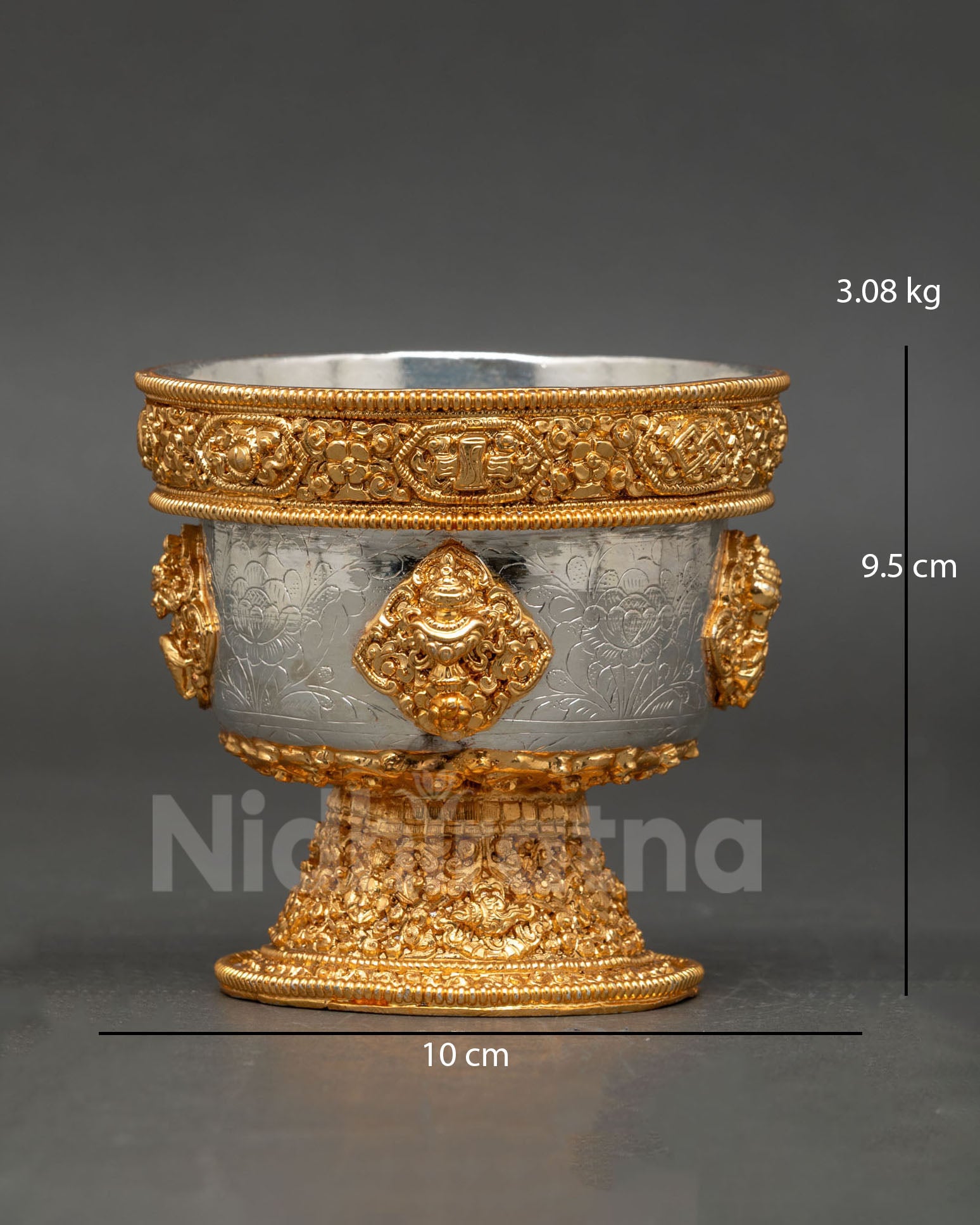 Close up detail water offering bowl showing intricate engraved symbols copper craftsmanship and refined gold and silver plated Himalayan Buddhist ritual design