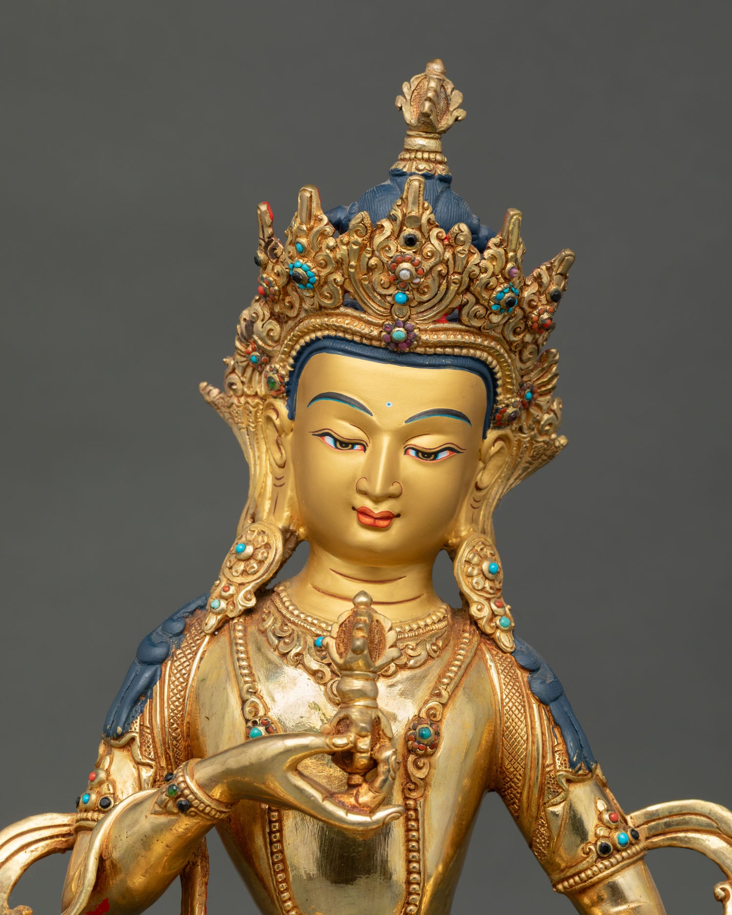 Close up Dorje Sempa Vajrasattva sculpture with gold painted face, semi precious stones, flowing robes and intricate sacred ornaments