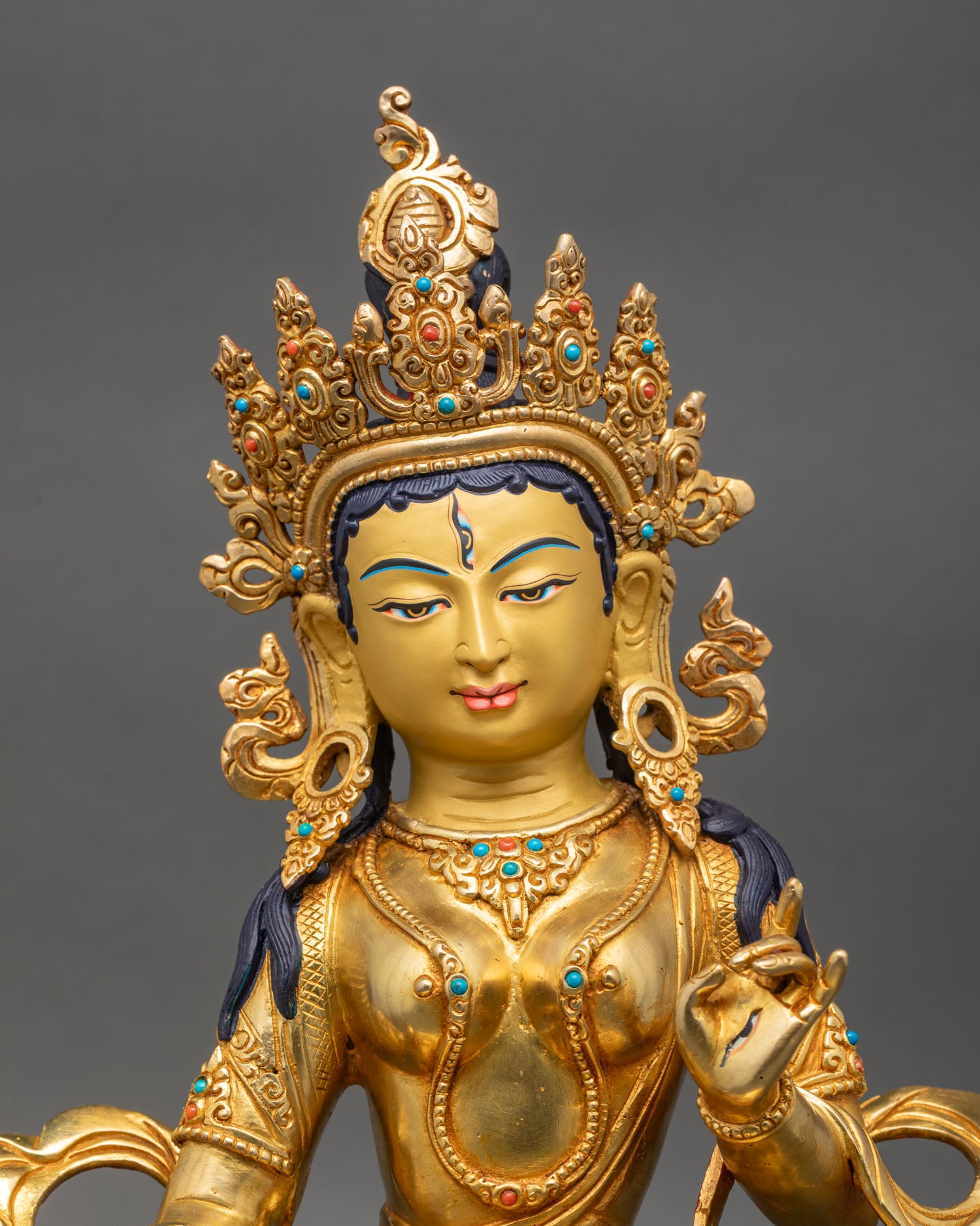 Close up Dukar face with gold painted expression and turquoise coral stone details