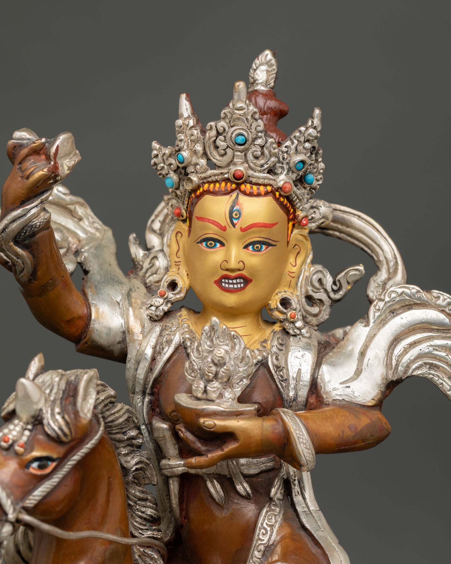 Close-up of enlightened dakini Achi Chokyi Drolma sculpture with gold painted face, semi precious stones detailed, Himalayan craftsmanship