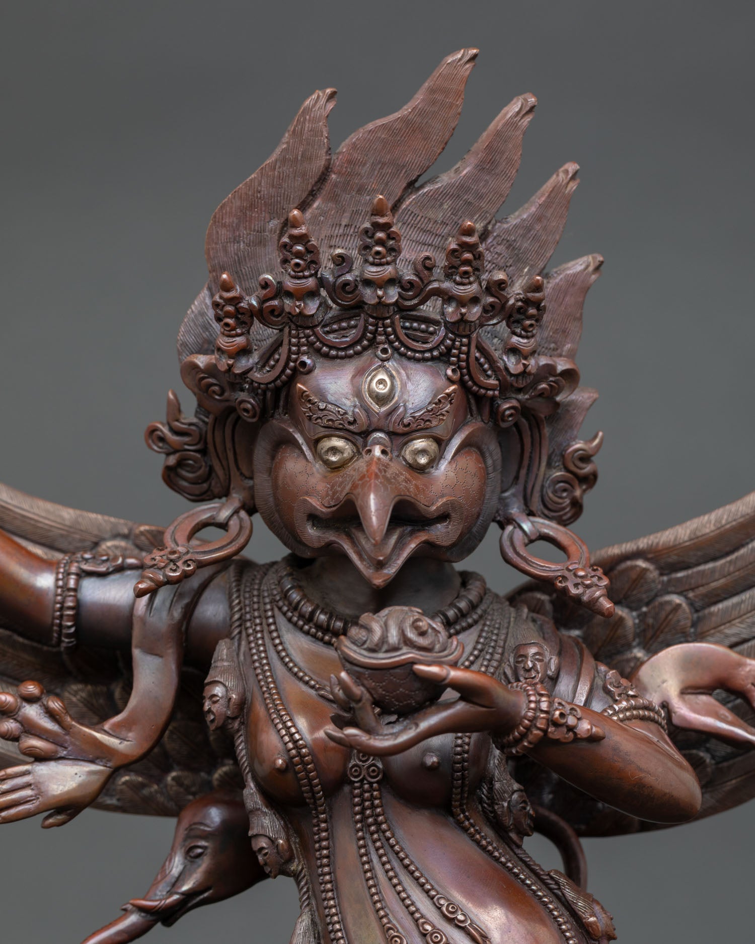 Close up Garuda statue expressive face and detailed wings oxidized copper Himalayan craftsmanship spiritual decor