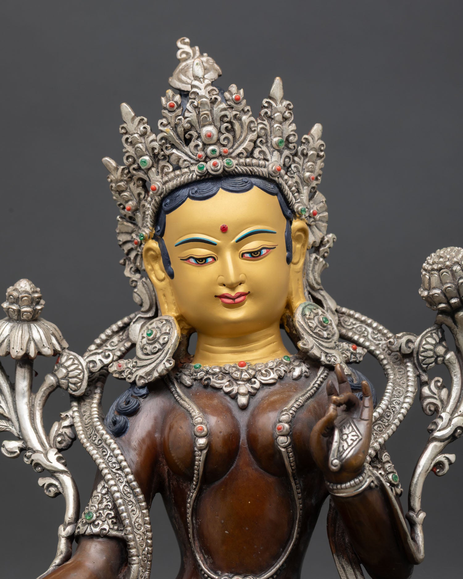 Close up of Green Tara face gold-painted serene expression handcrafted Nepal