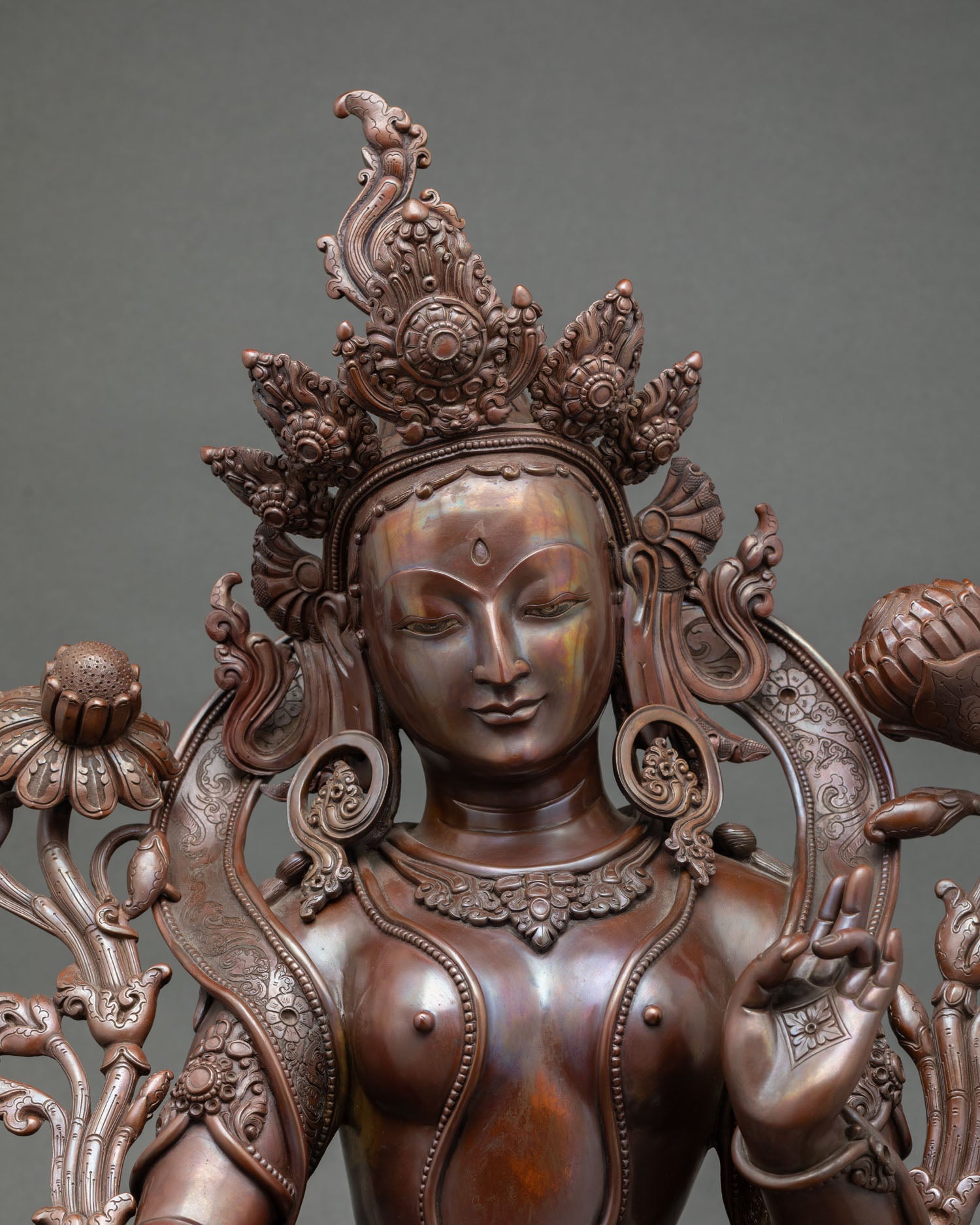 Close up of Green Tara face handcrafted Newari art copper statue utpala lotus symbol Buddhist compassion deity Nepal