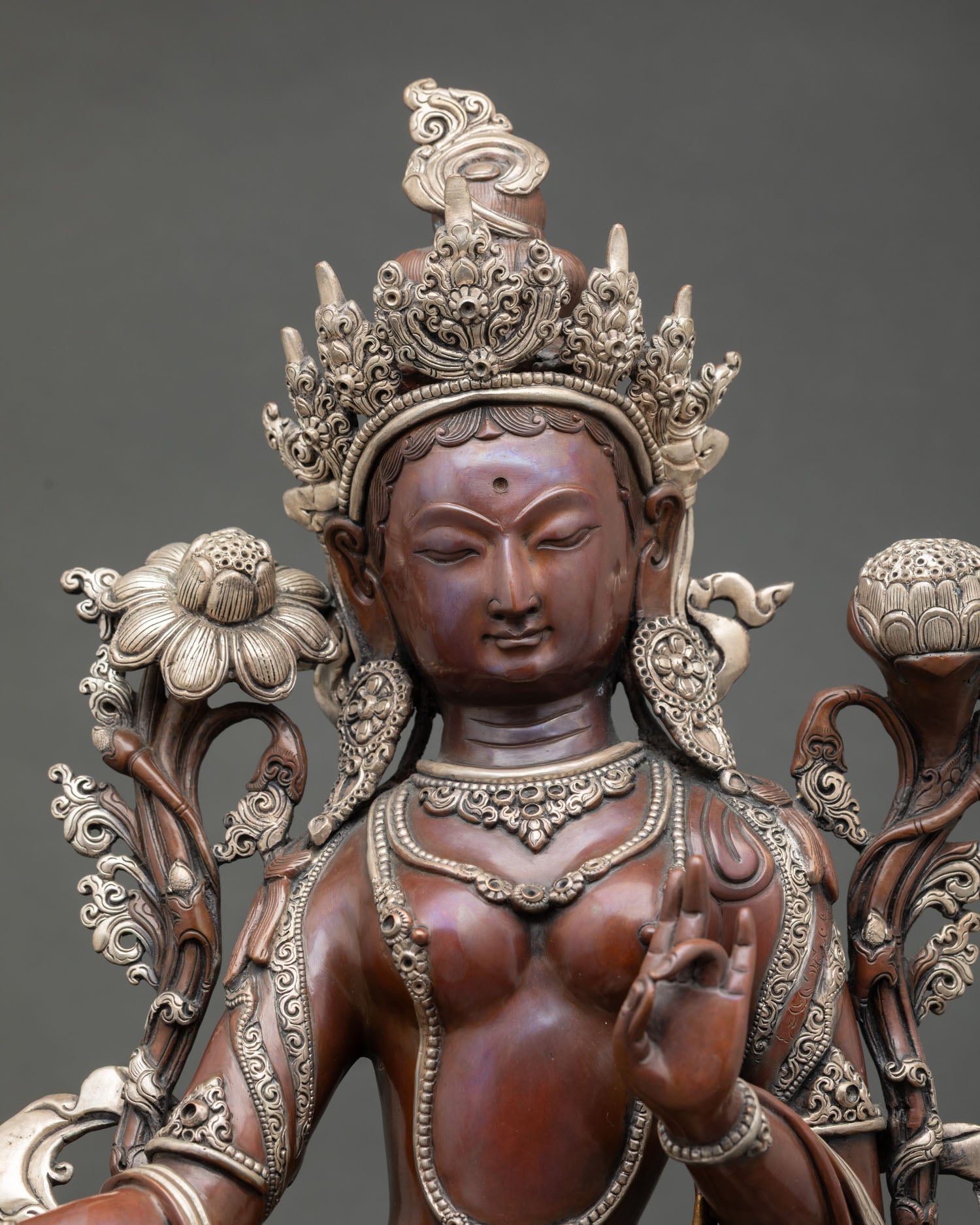 Close up Green Tara face with radiant halo Utpala lotus flower and intricate crown details sacred Himalayan Buddhist art from Nepal