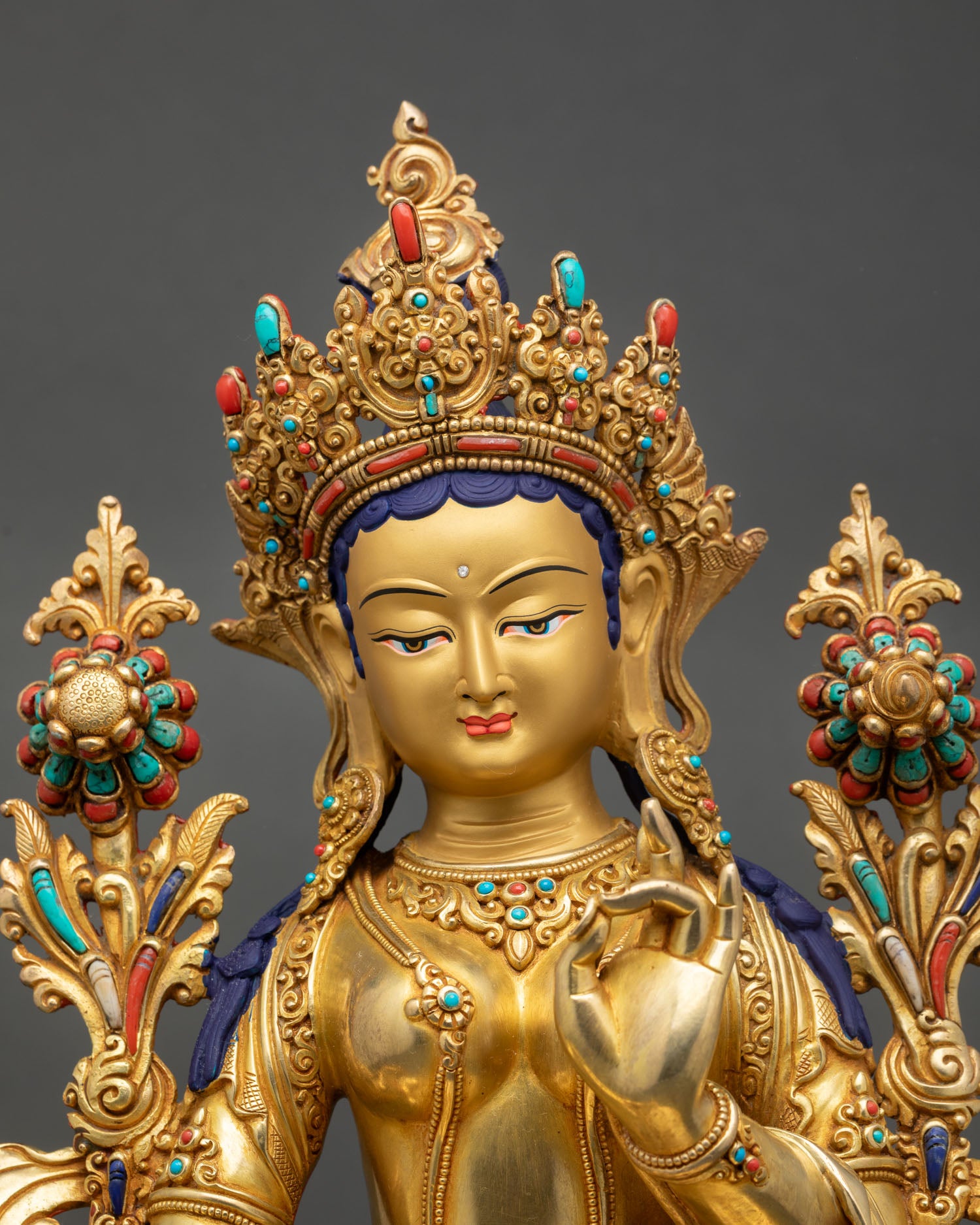 Close up Green Tara goddess statue gold painted serene face detailed expression Himalayan craftsmanship sacred Buddhist art