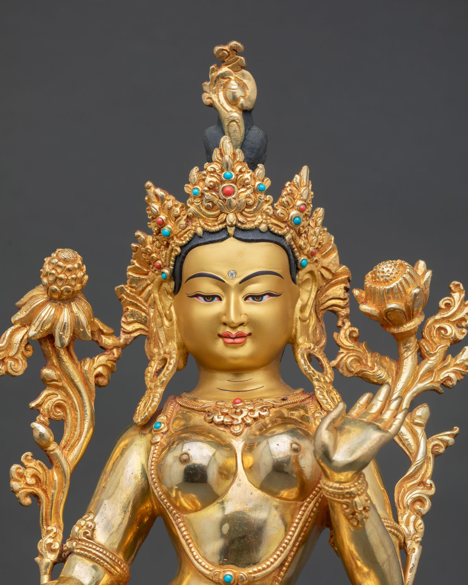 Close up Green Tara goddess statue with ornate crown semi precious stones, Himalayan Buddhist artwork for spiritual decor