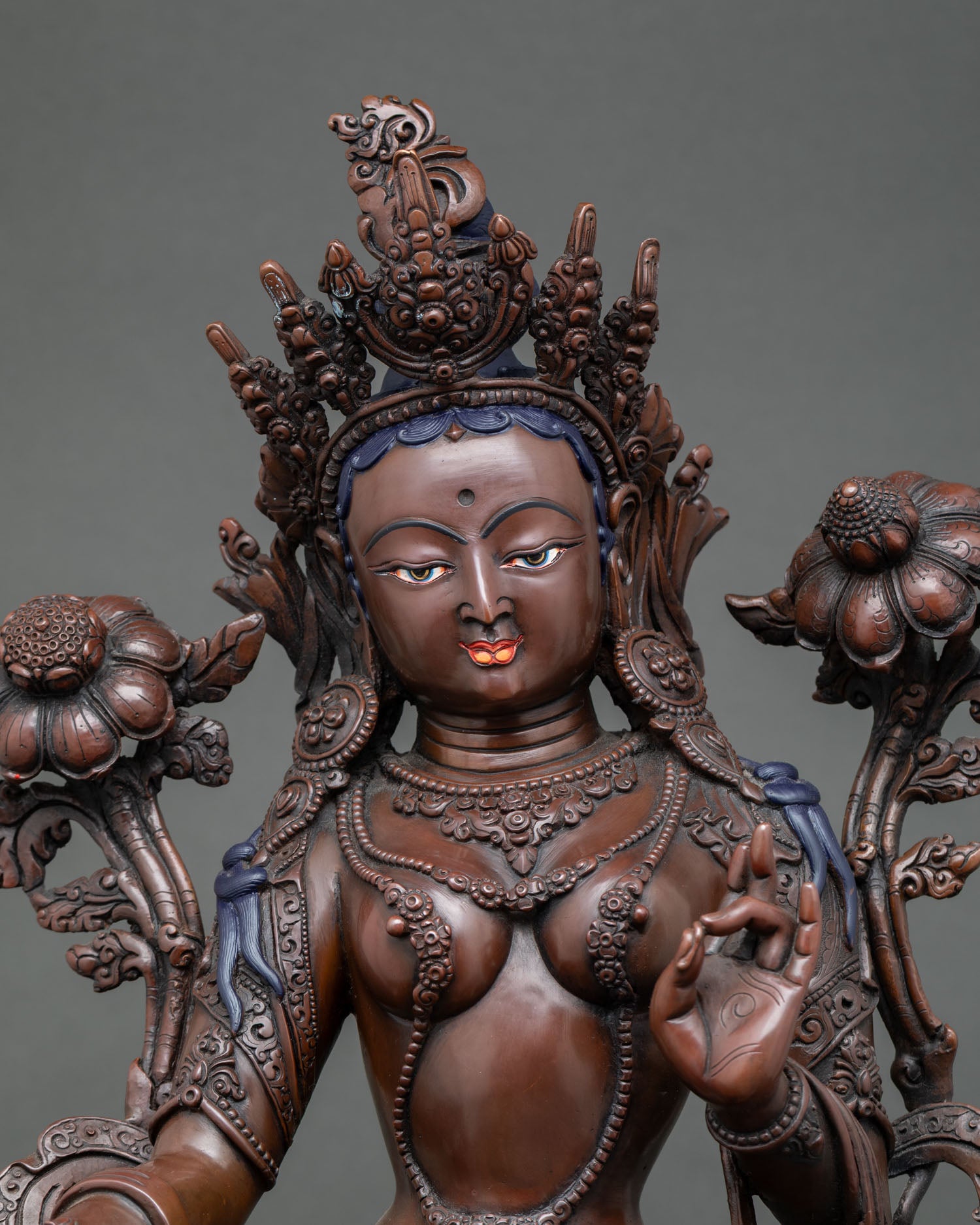 Close-up, Green Tara statue, serene face, intricate crown, sacred jewelry, oxidized copper, Himalayan Buddhist art