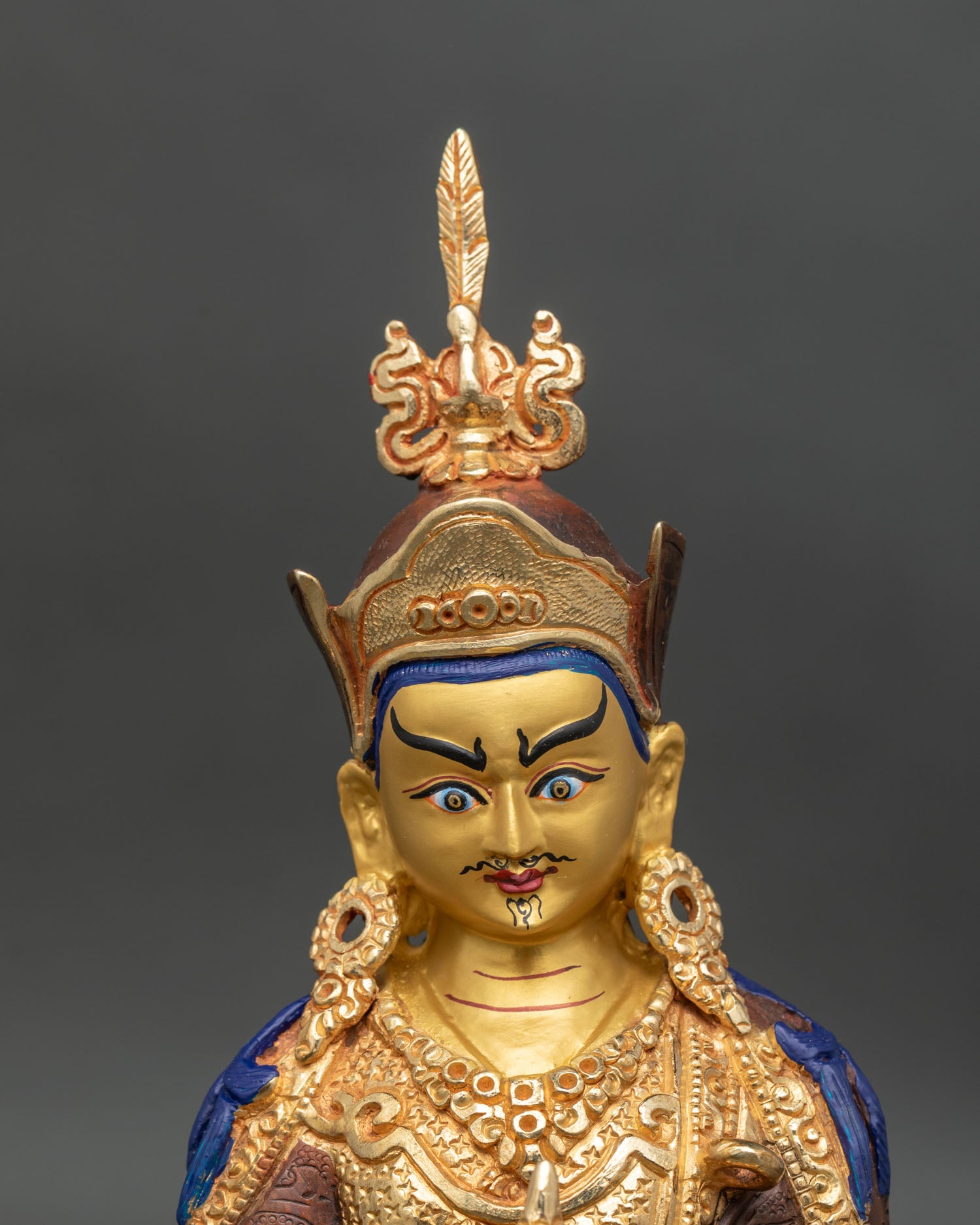 Close up Guru Padmasambhava face hand-painted acrylic details Newari craftsmanship statue