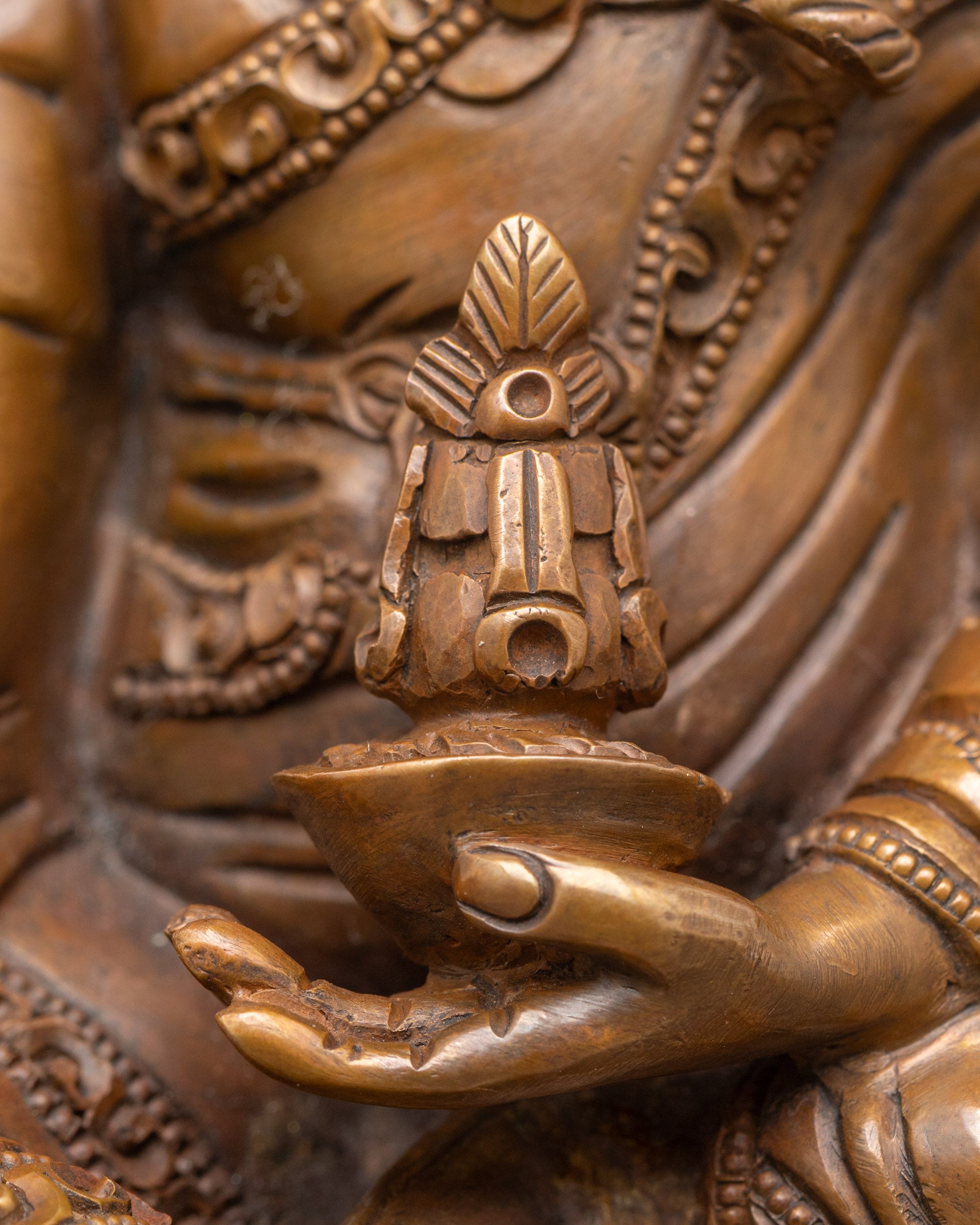 Close-up of Guru Rinpoche Padmasambhava statue with detailed oxidized copper features