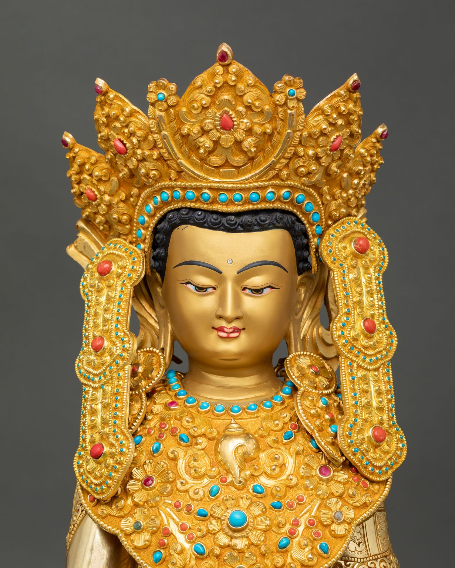 Close up Jowo Rinpoche Shakyamuni Buddha statue with golden painted face, five Buddha crown and semi precious stone necklace detail