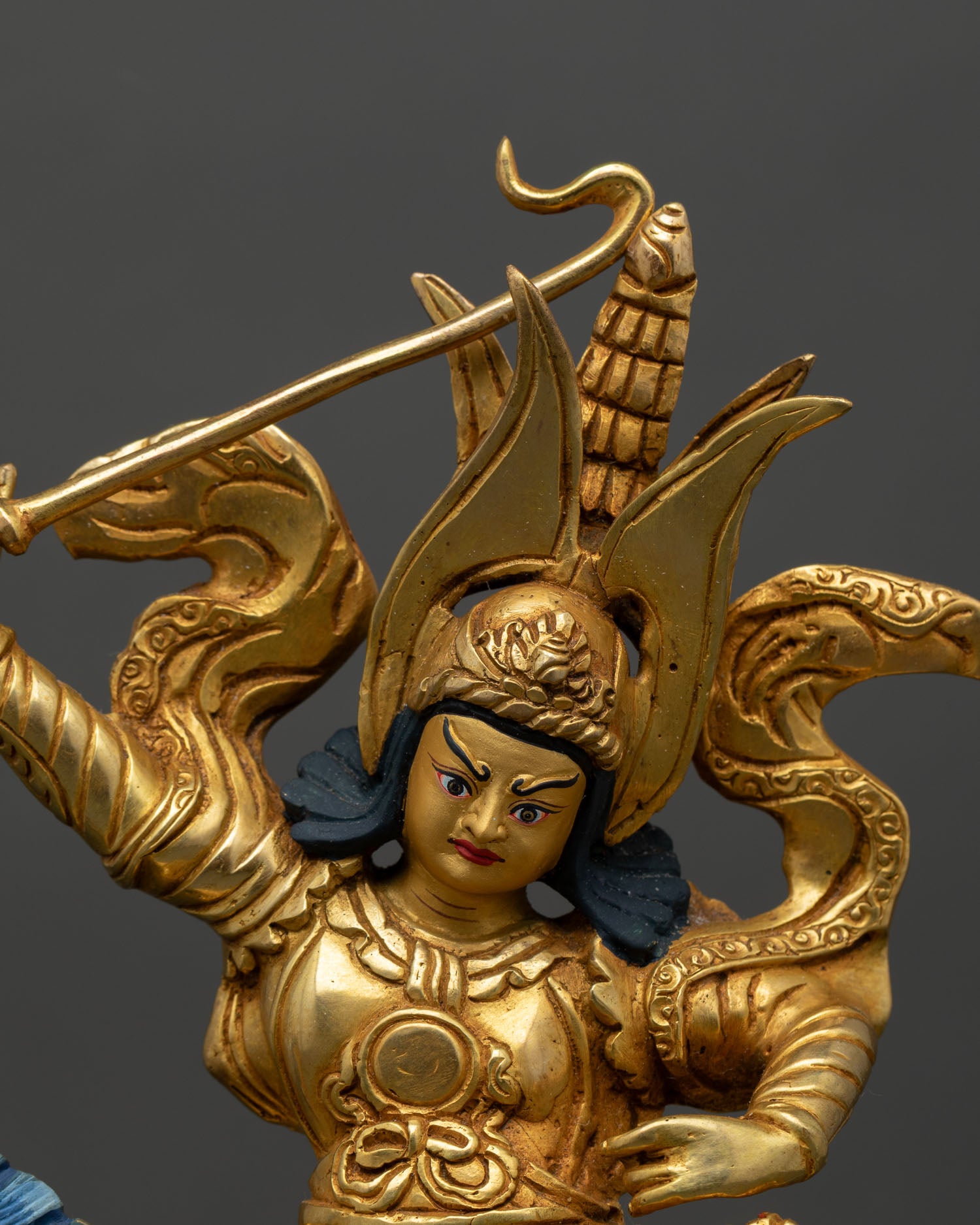 Close up King Ghesar statue showing finely crafted armor details, warrior expression, and sacred sword staff