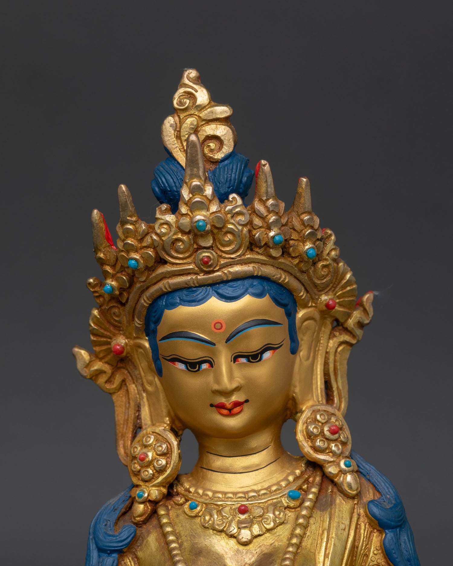 close up kshitigarbha face detail gold painted serene expression cintamani jewel