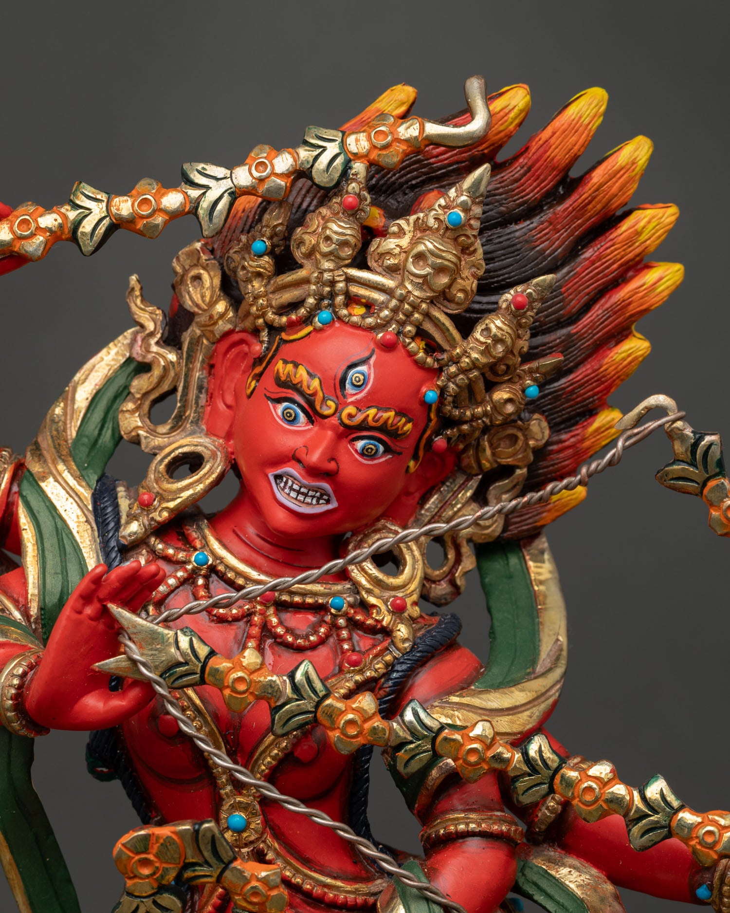 Close up Kurukulla statue detailed view showing four arms, adorned with semi precious stones and rich acrylic colors Himalayan Buddhist spiritual art