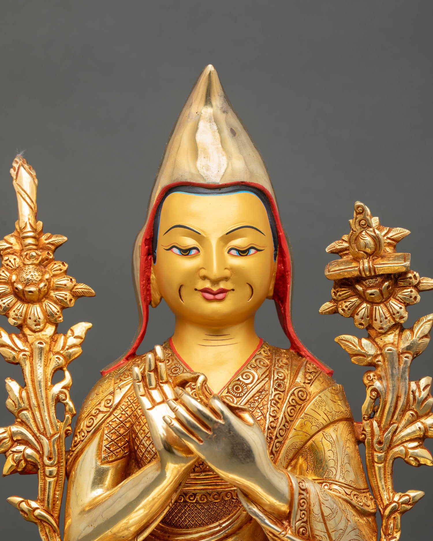 Close up Lama Je Tsongkhapa face yellow pandita hat gold fire gilded detail Tibetan Buddhist master statue