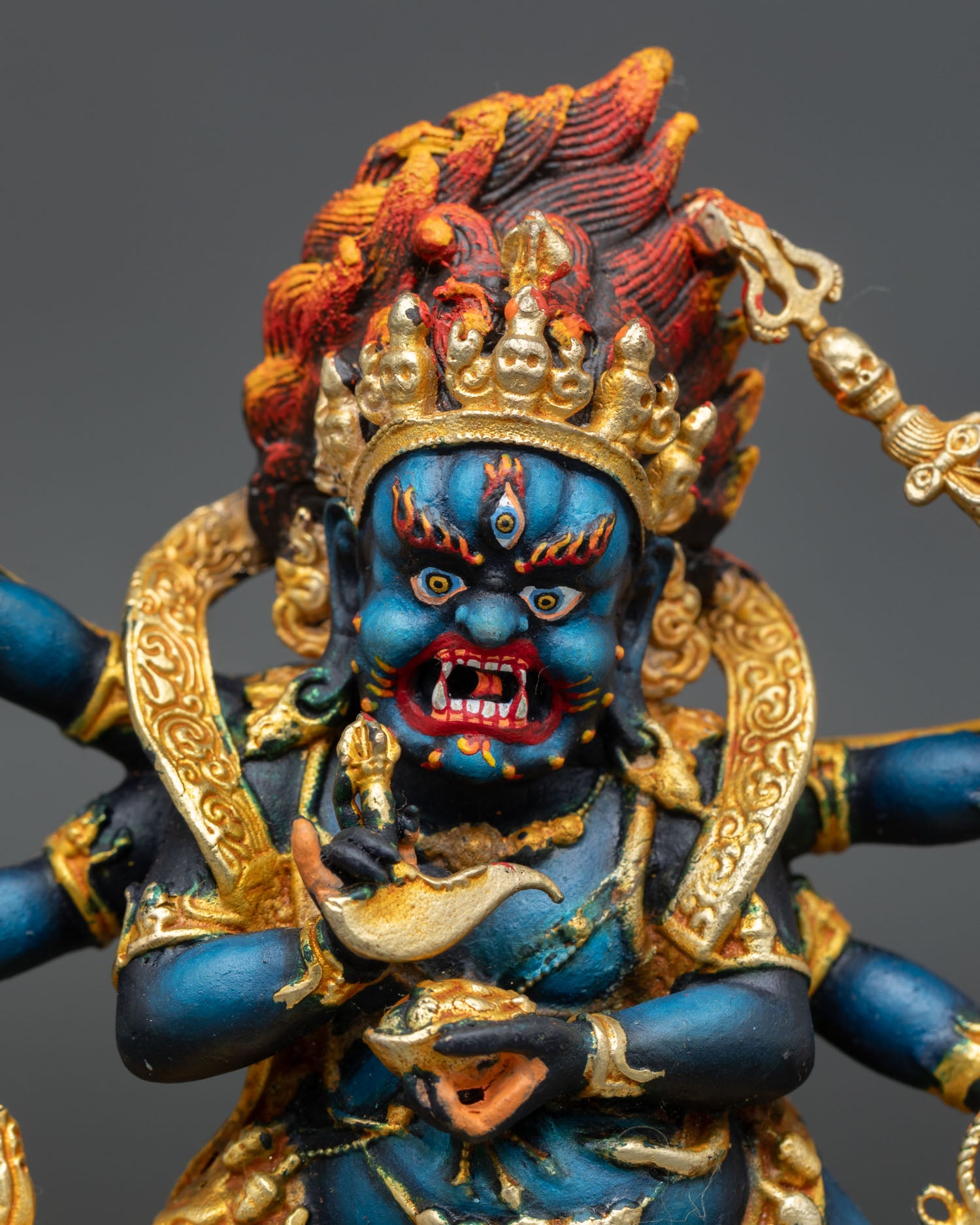 Close up Mahakala fierce face with intense expression crushing subdued figure and symbol of victory over ignorance