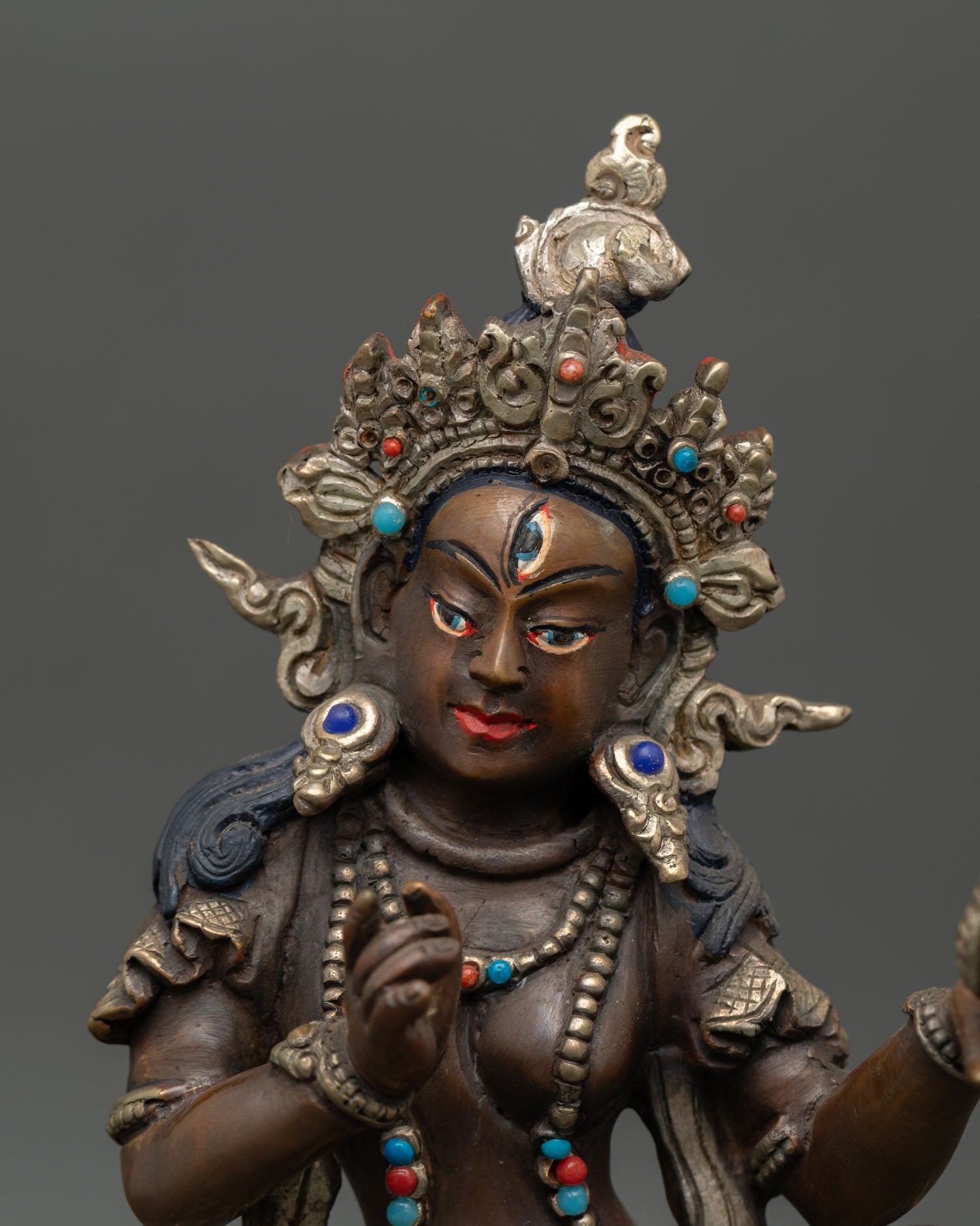 Close up Mandarava dakini statue detail, serene face, handmade copper sculpture Patan Nepal, Vajrayana Buddhist spiritual art with silver plated finish