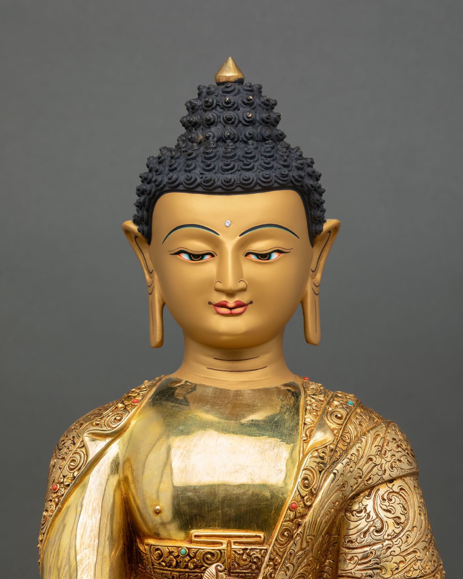 Close up Medicine Buddha face gold painted serene expression Himalayan Buddhist art