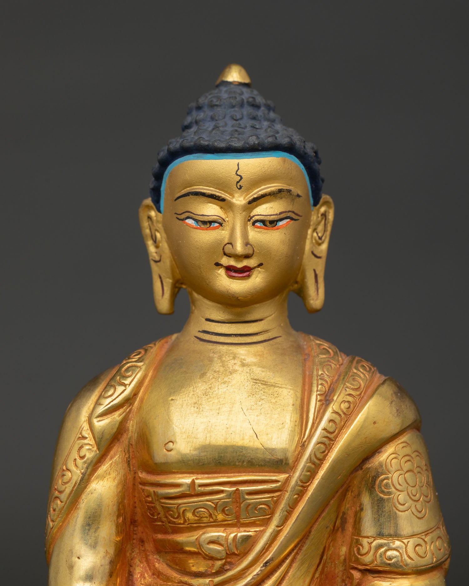 Close up of Amitabha Buddha gold painted face with intricate halo and Newari craftsmanship.