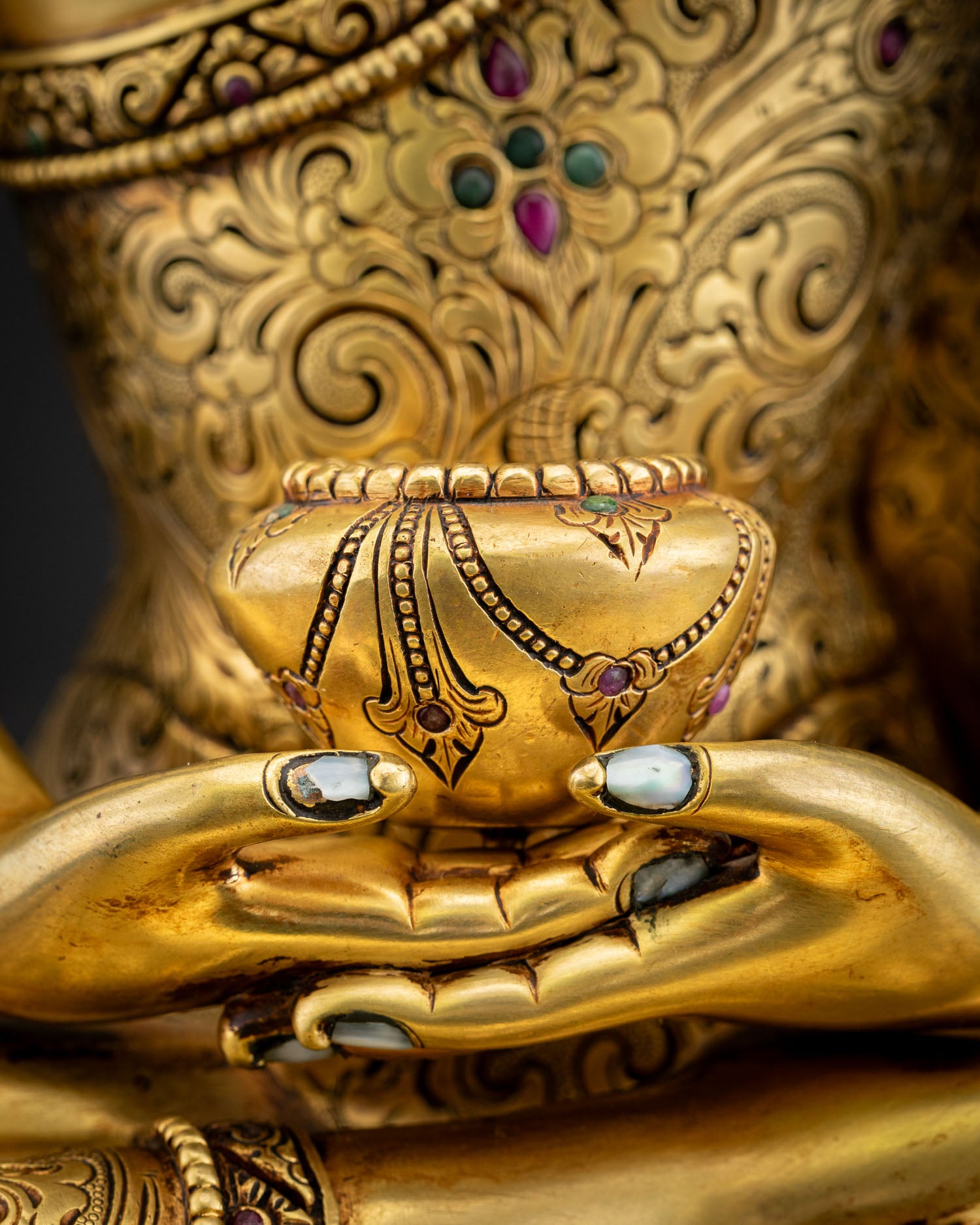 Close‑up of Amitabha Buddha statue Patra Bowl resting in lap, gold fire‑gilded copper with fine repoussé detailing