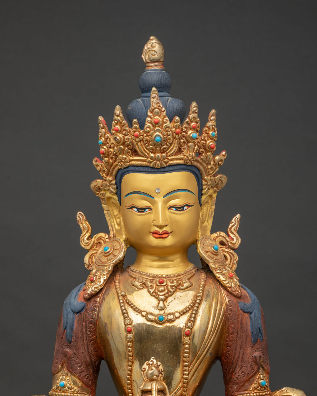Close Up Of Amitayus Buddha Statue With Gold Painted Face And Crown