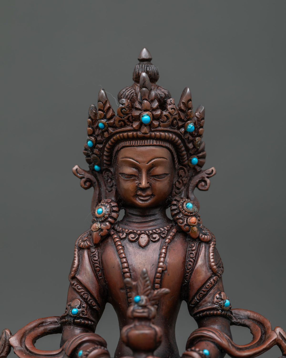 Close up of amitayus face five jewel crown and handcarved silk garment details.
