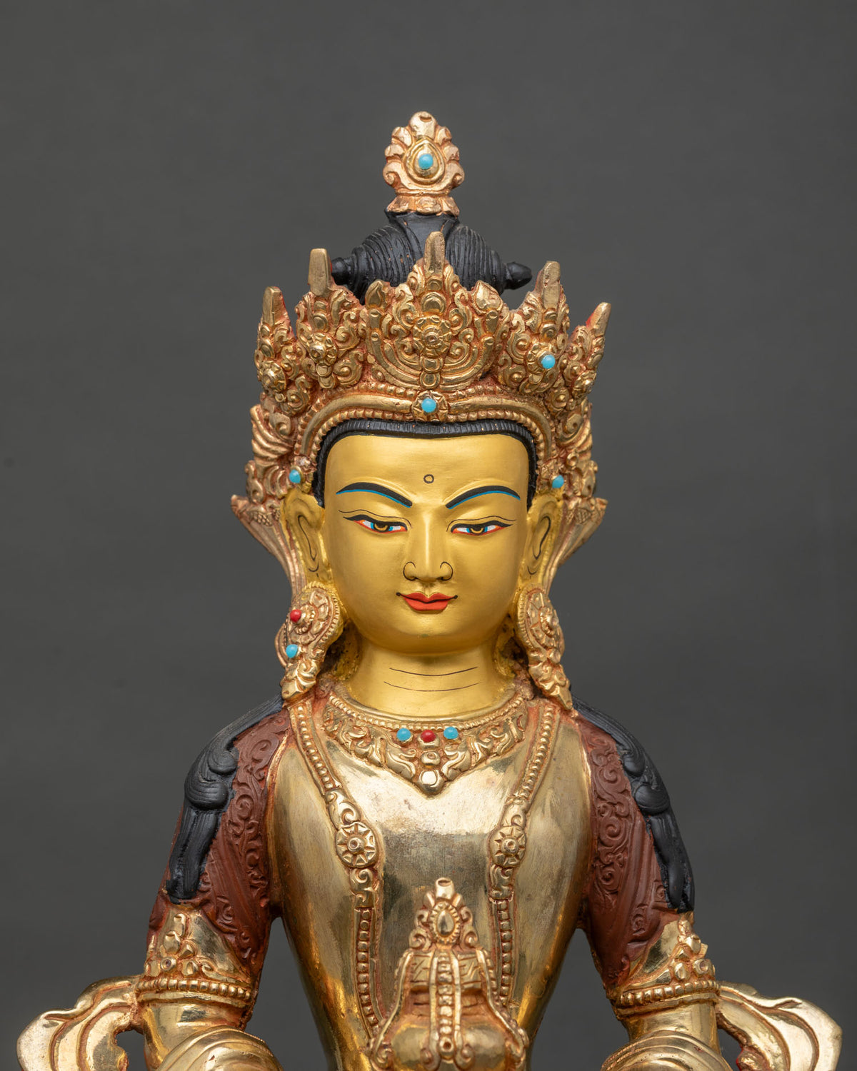 Close-up of Amitayus statue face and ornate crown with semi-precious stone accents