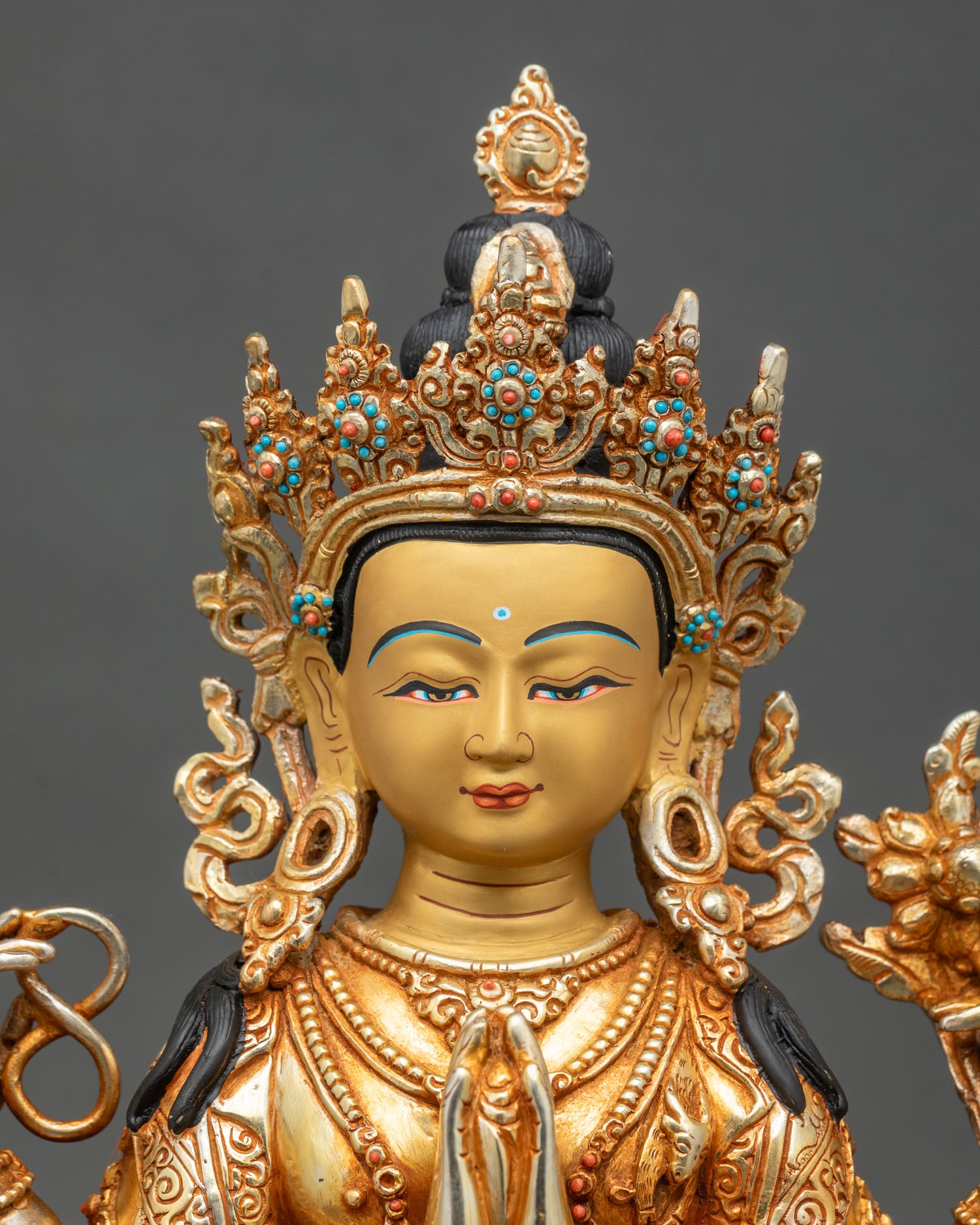 Close-up of Avalokiteshvara Chenrezig statue showing fire-gilded gold and copper craftsmanship