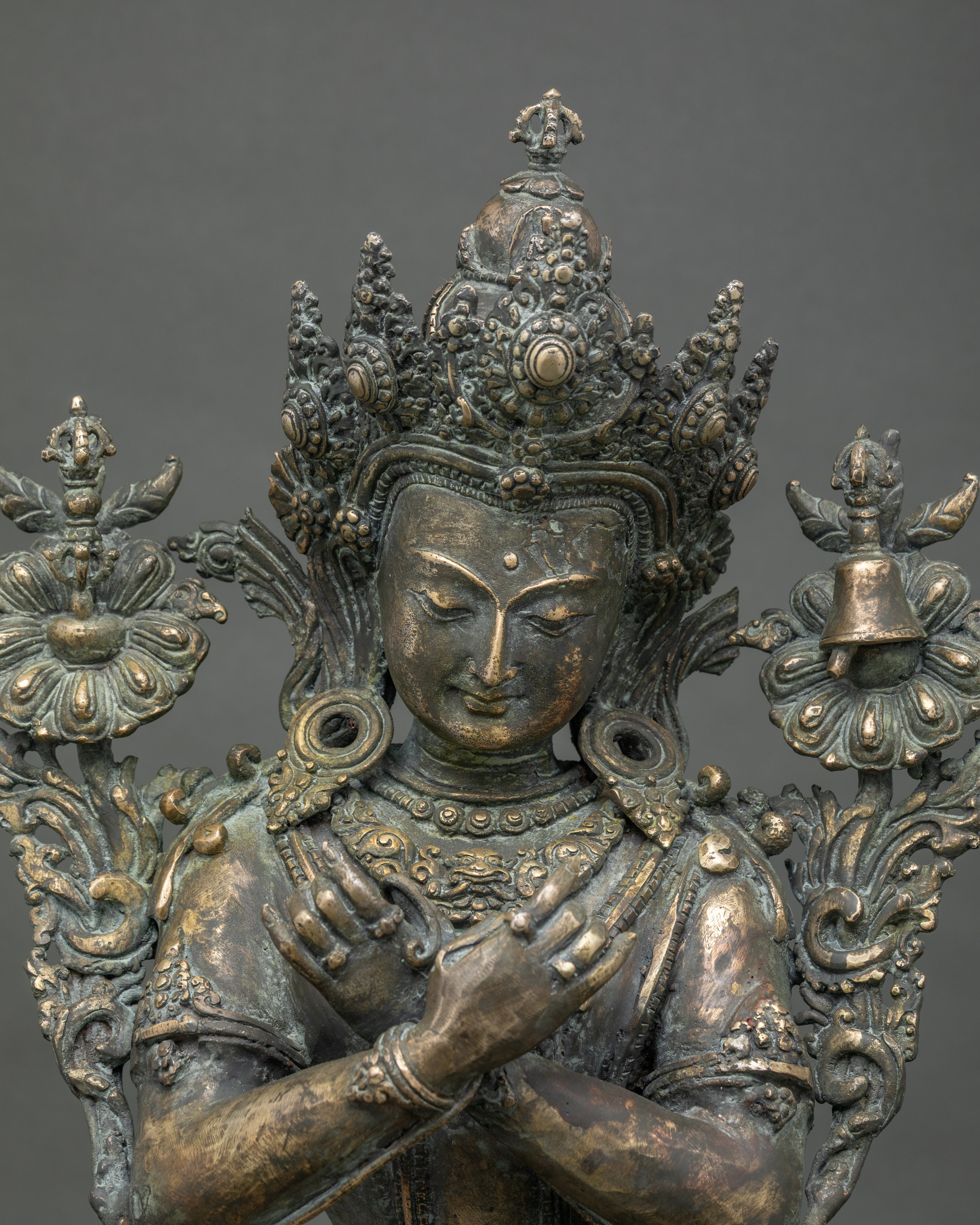 Close-up of bronze Vajradhara statue showing jeweled crown and carved robe detail