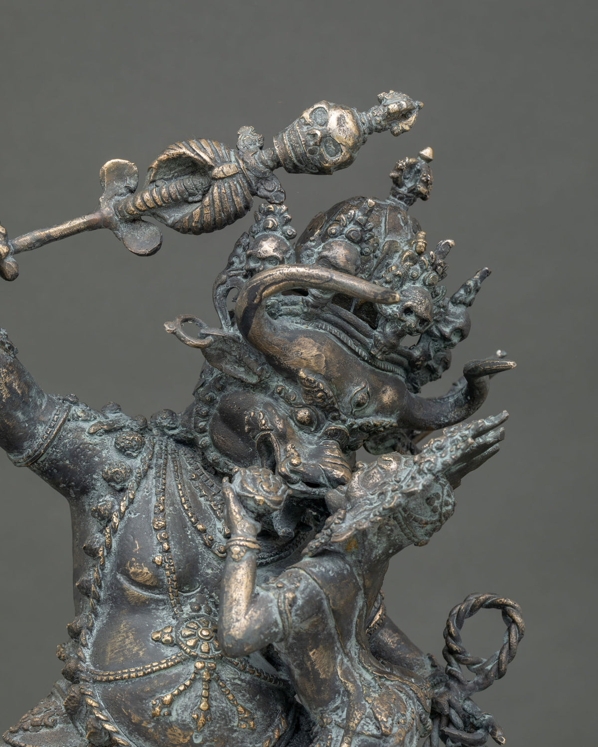 Close-up of bronze Yamantaka statue showing khatvanga staff, ornate garlands and Vajravetali consort