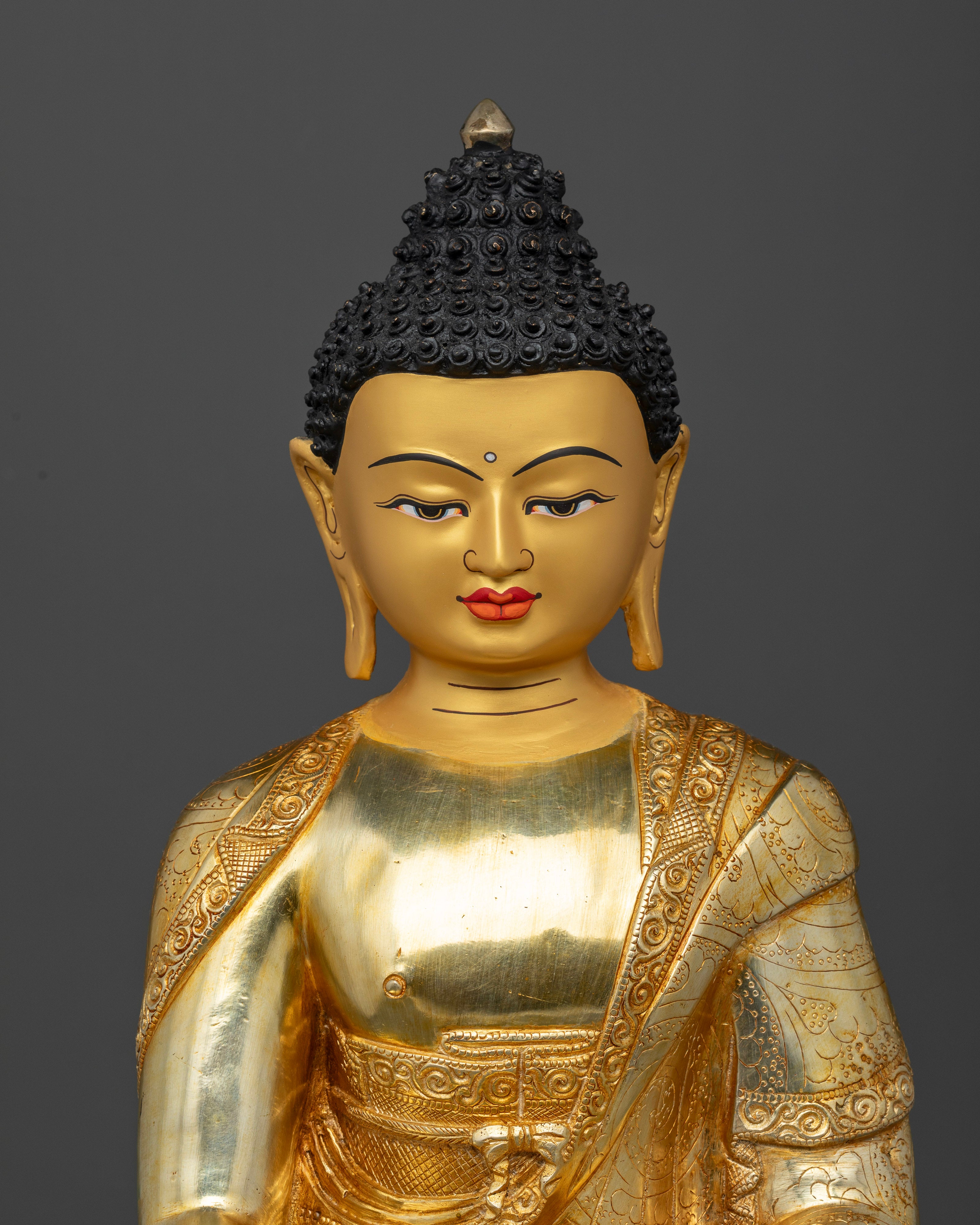 Close Up of Buddha Shakyamuni Statue with Gold Painted Face and Carved Robe Details
