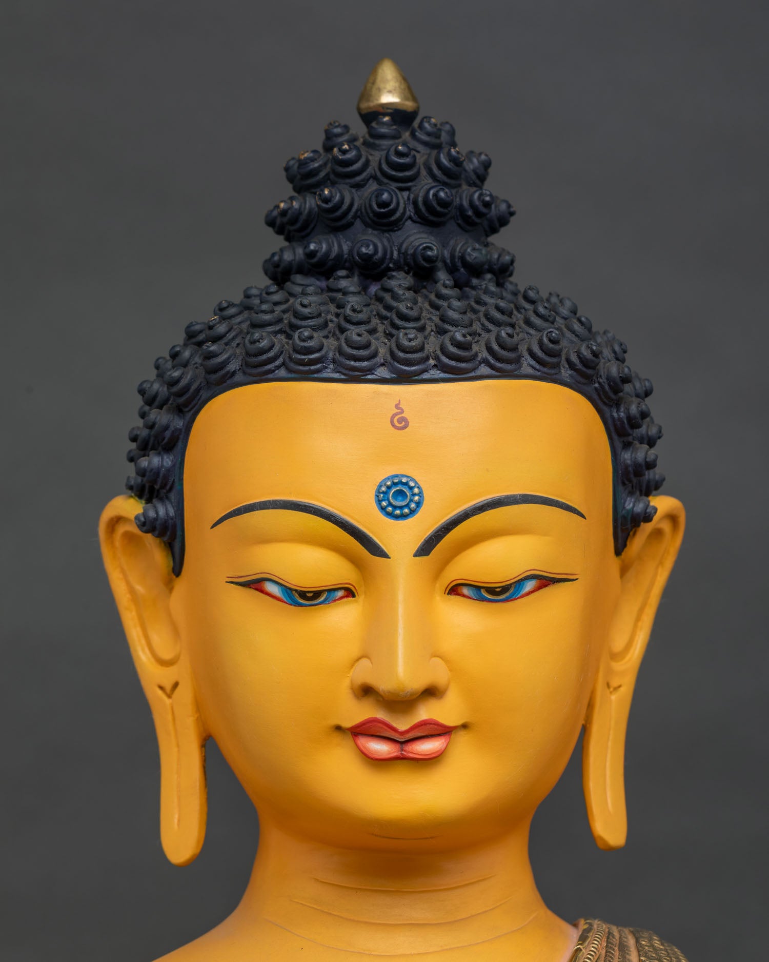 Close-up of Shakyamuni Buddha's serene face, gold gilding, handcrafted in Nepal