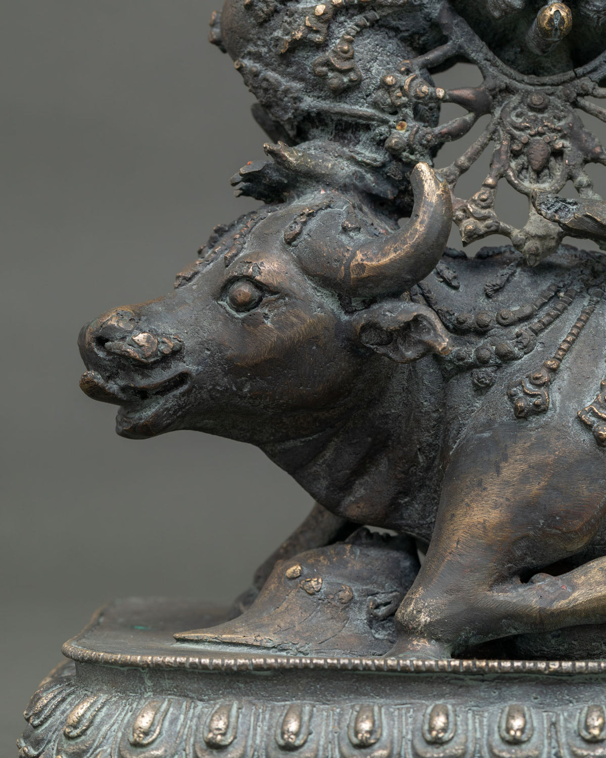 Close-up of buffalo head with curved horn and lotus-petal base on Yamantaka bronze statue