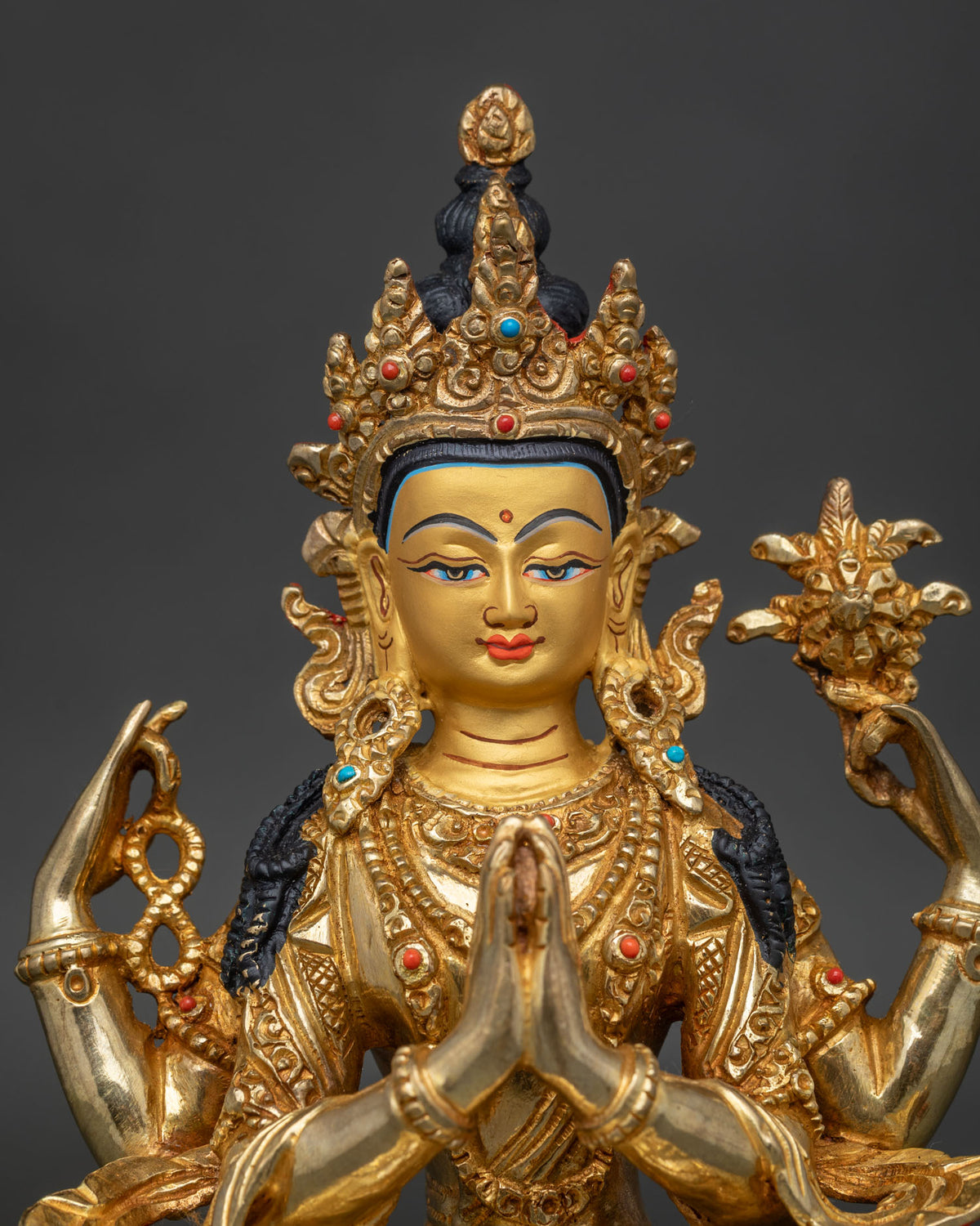 Close up of Chenrezig 24k gold painted face with sacred mala and ornate buddhist jewelry.