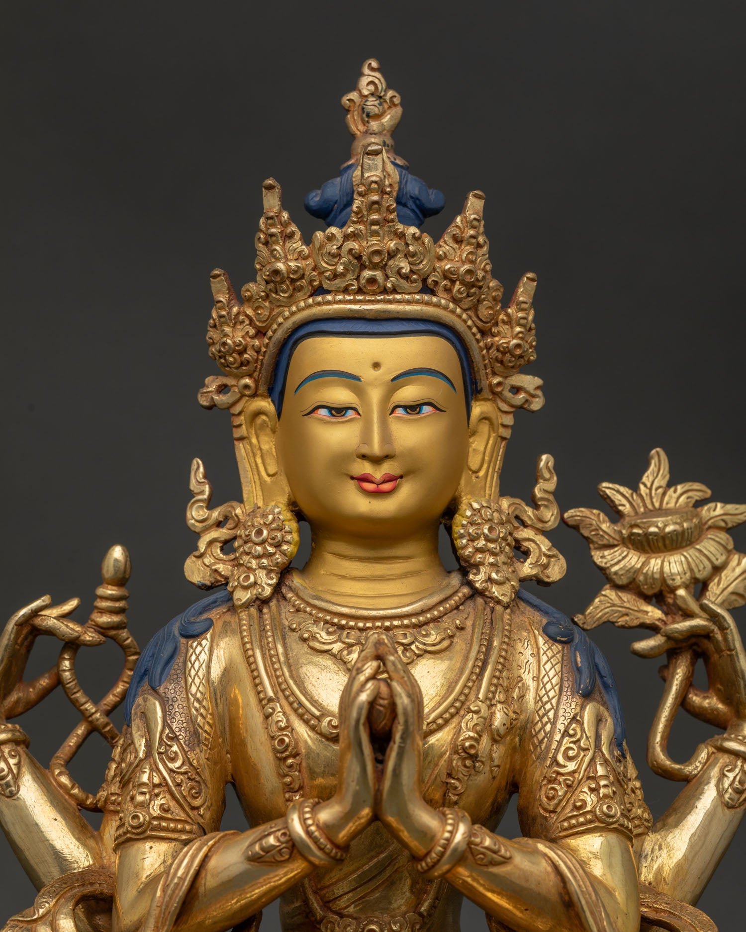 Close Up of Chenrezig Bodhisattva Statue with Gold Painted Face and Compassionate Expression