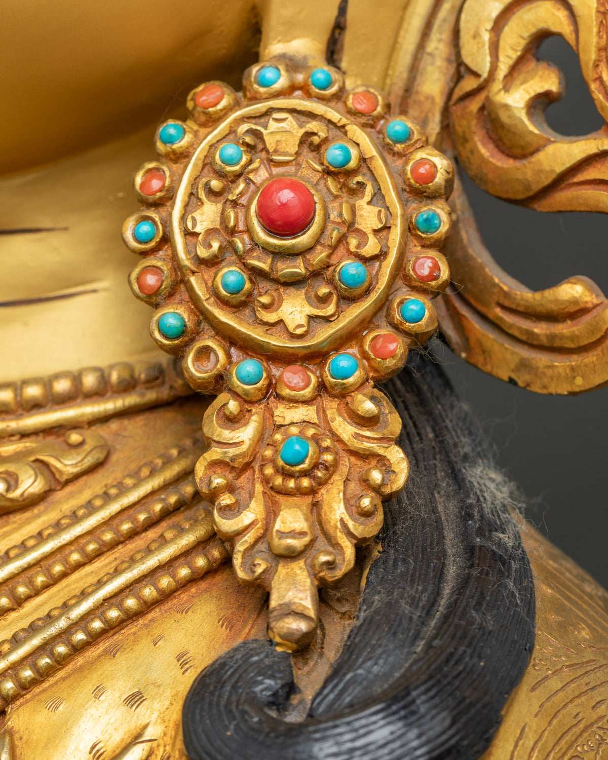Close-up of Chenrezig statue hands joined at heart in devotional anjali mudra gesture